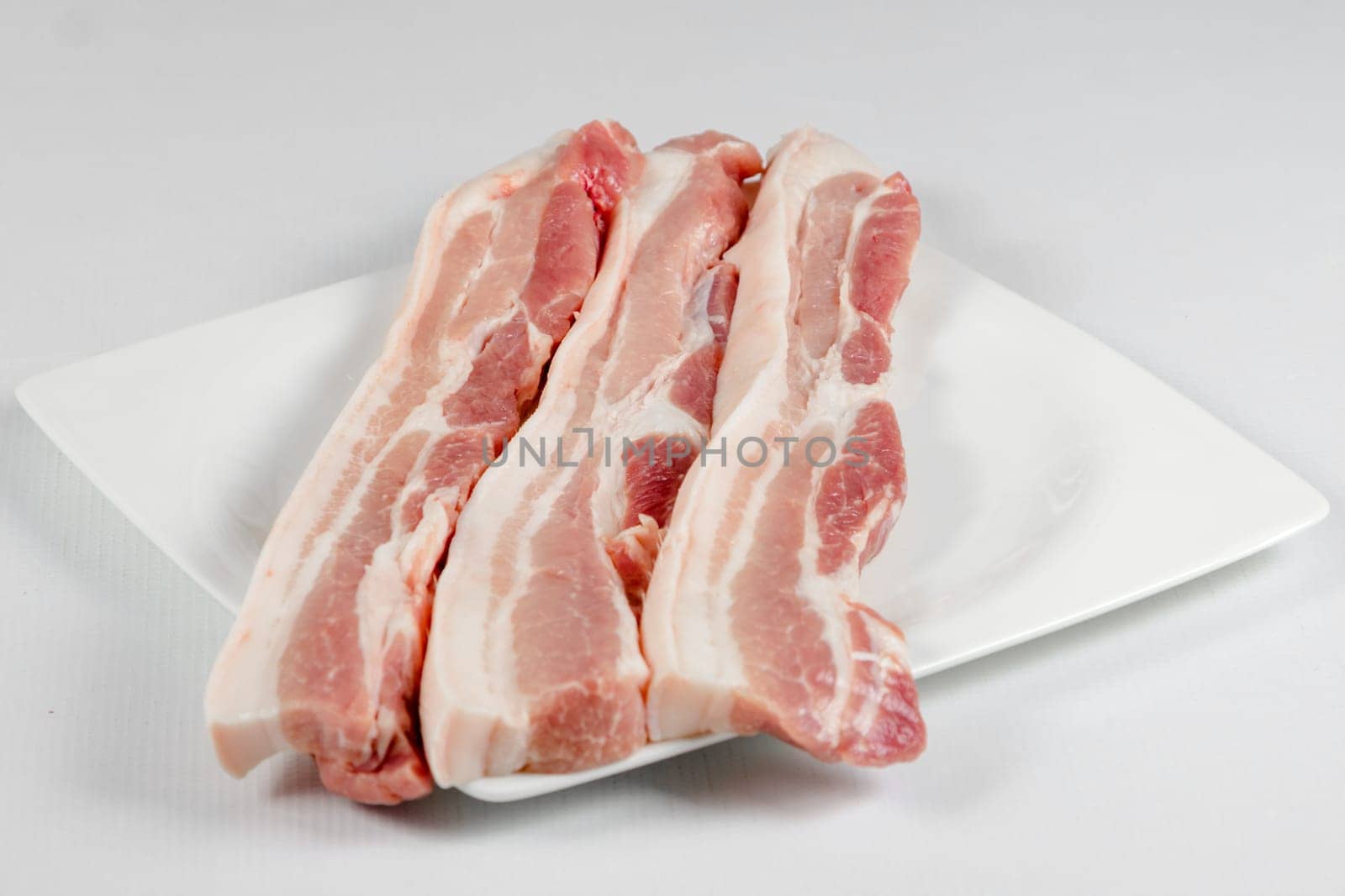 streaky pork in plate on white background
