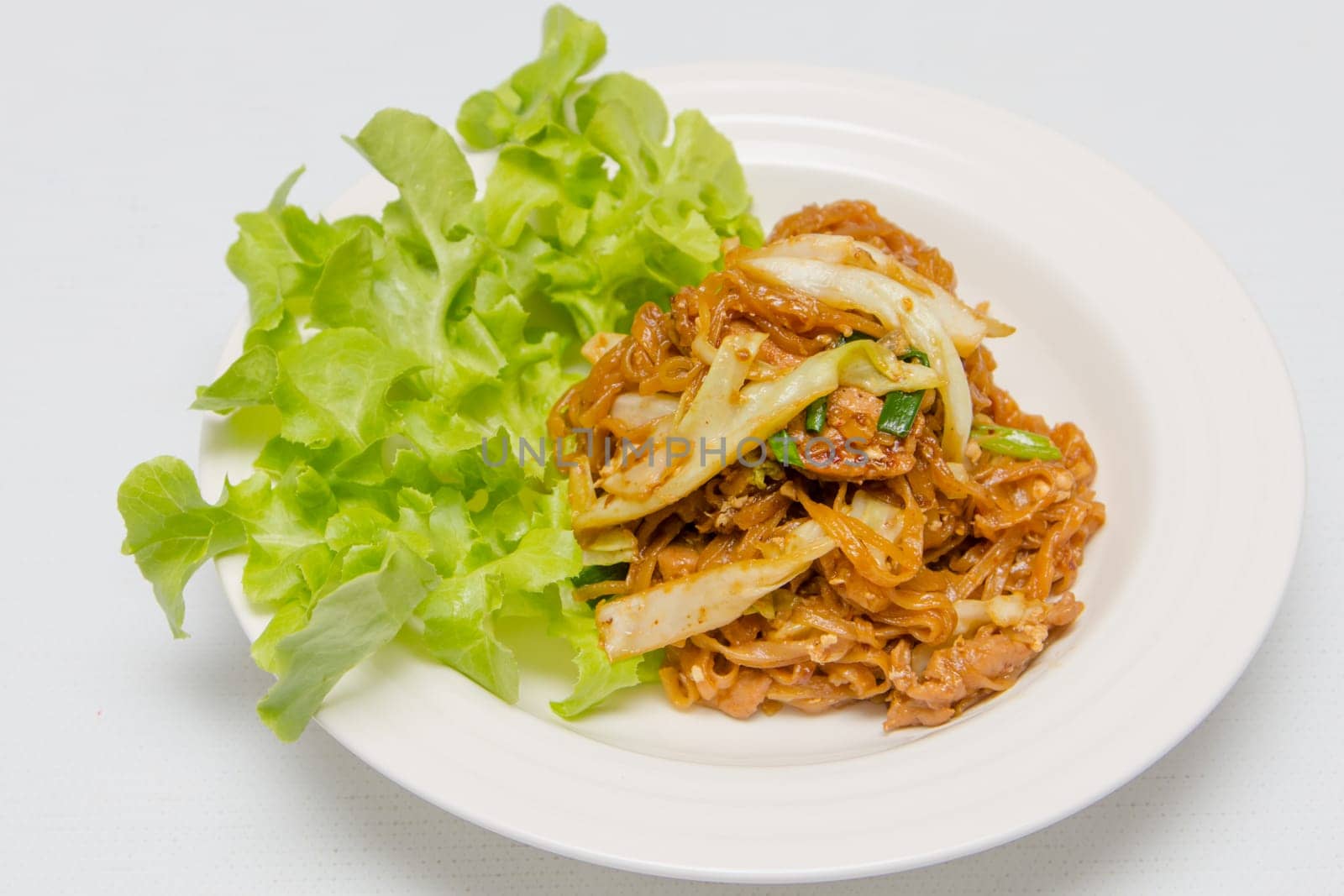 chef making fried noodle in white plate