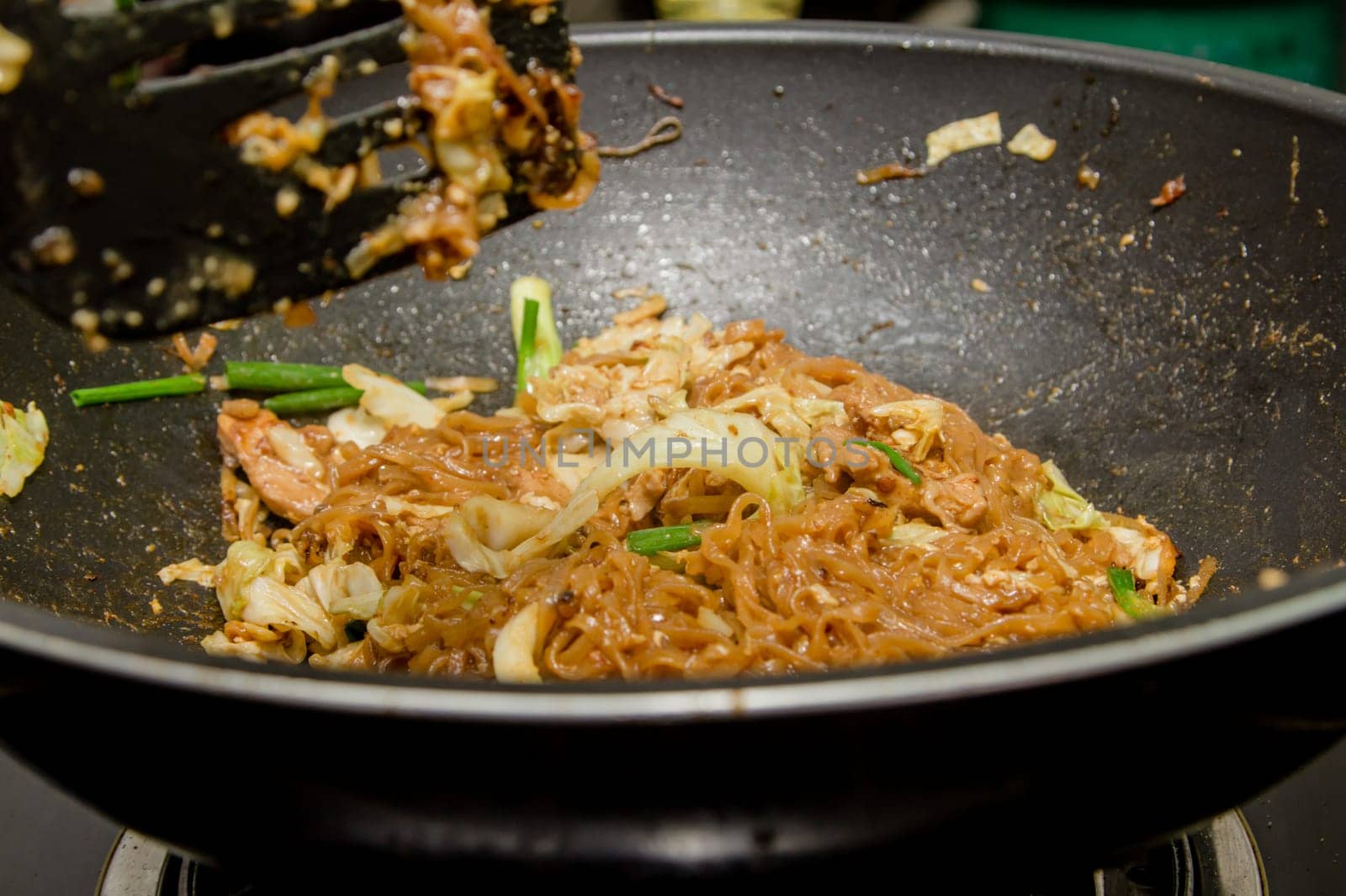 chef making fried noodle in pan for thai food menu