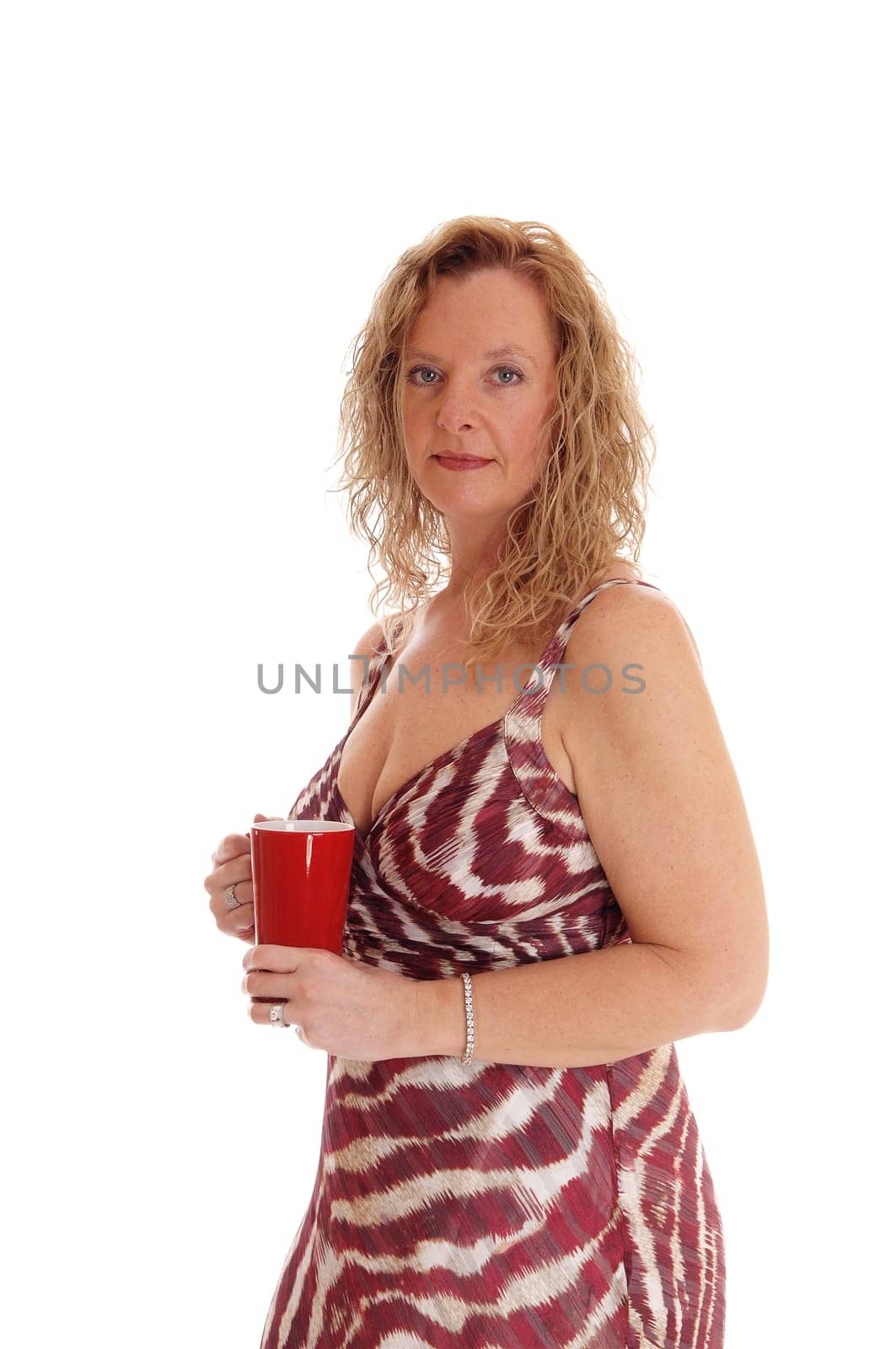 A image of a blond woman in a summer dress standing in profile holding.a red coffee mug, isolated for white background..