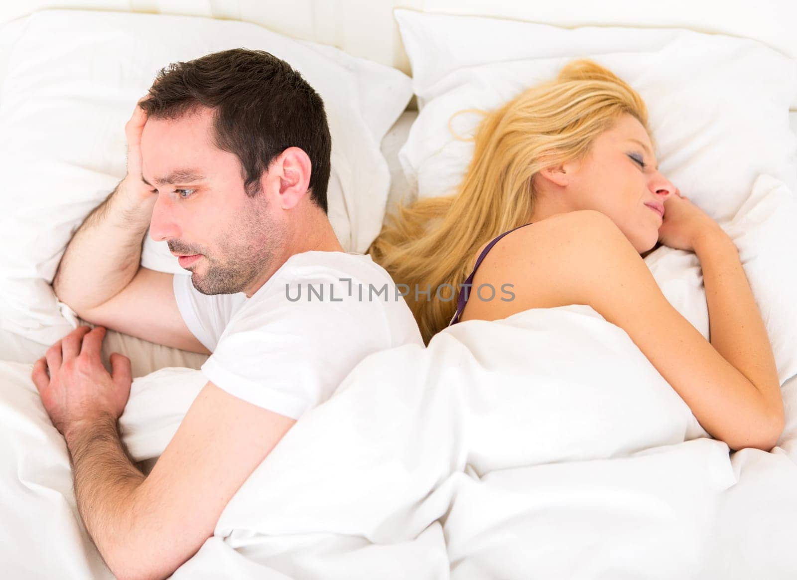 VIew of a Young attractive pensive man in a bed