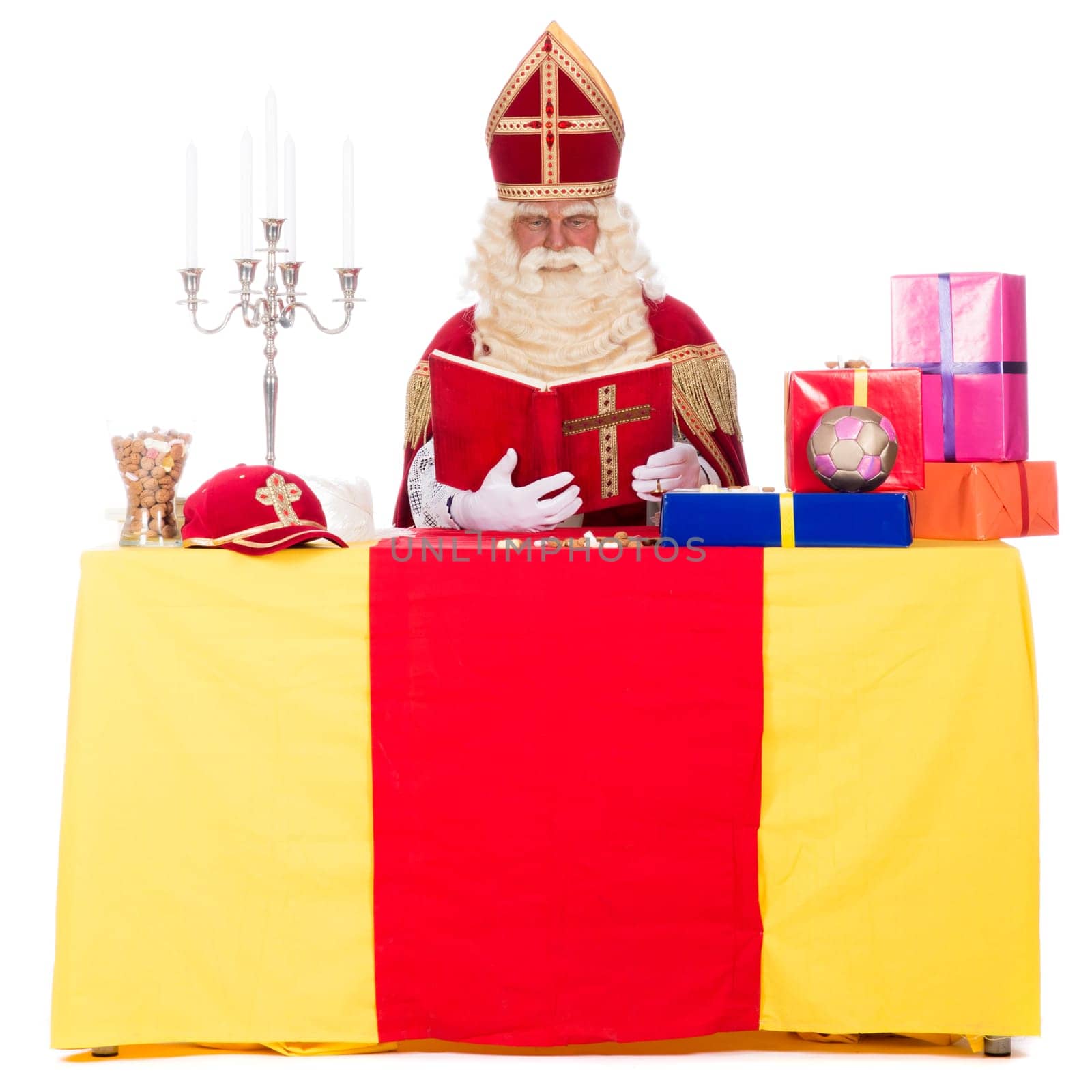 Sinterklaas is working at his desk, at a white background