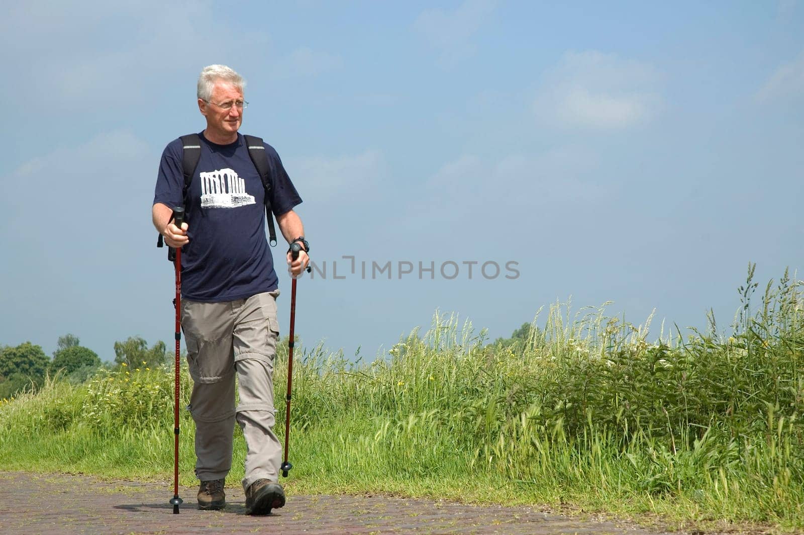 Senior man doing a Nordic Walk on a sunny day.