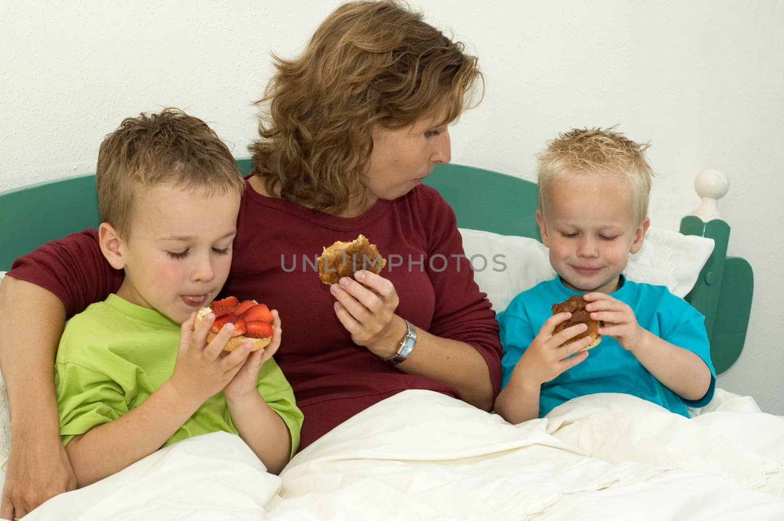 Happy family eating a raisin bun on a lazy sunday morning.