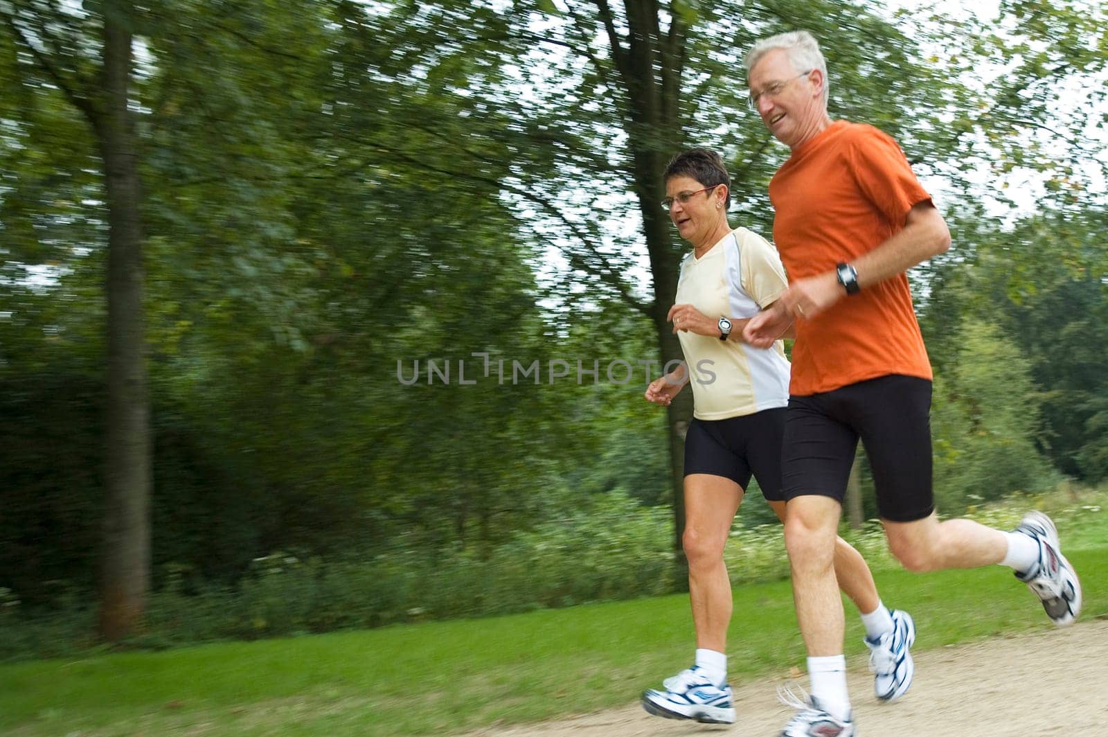 Running senior couple with motion in the picture. Focus is on the woman.