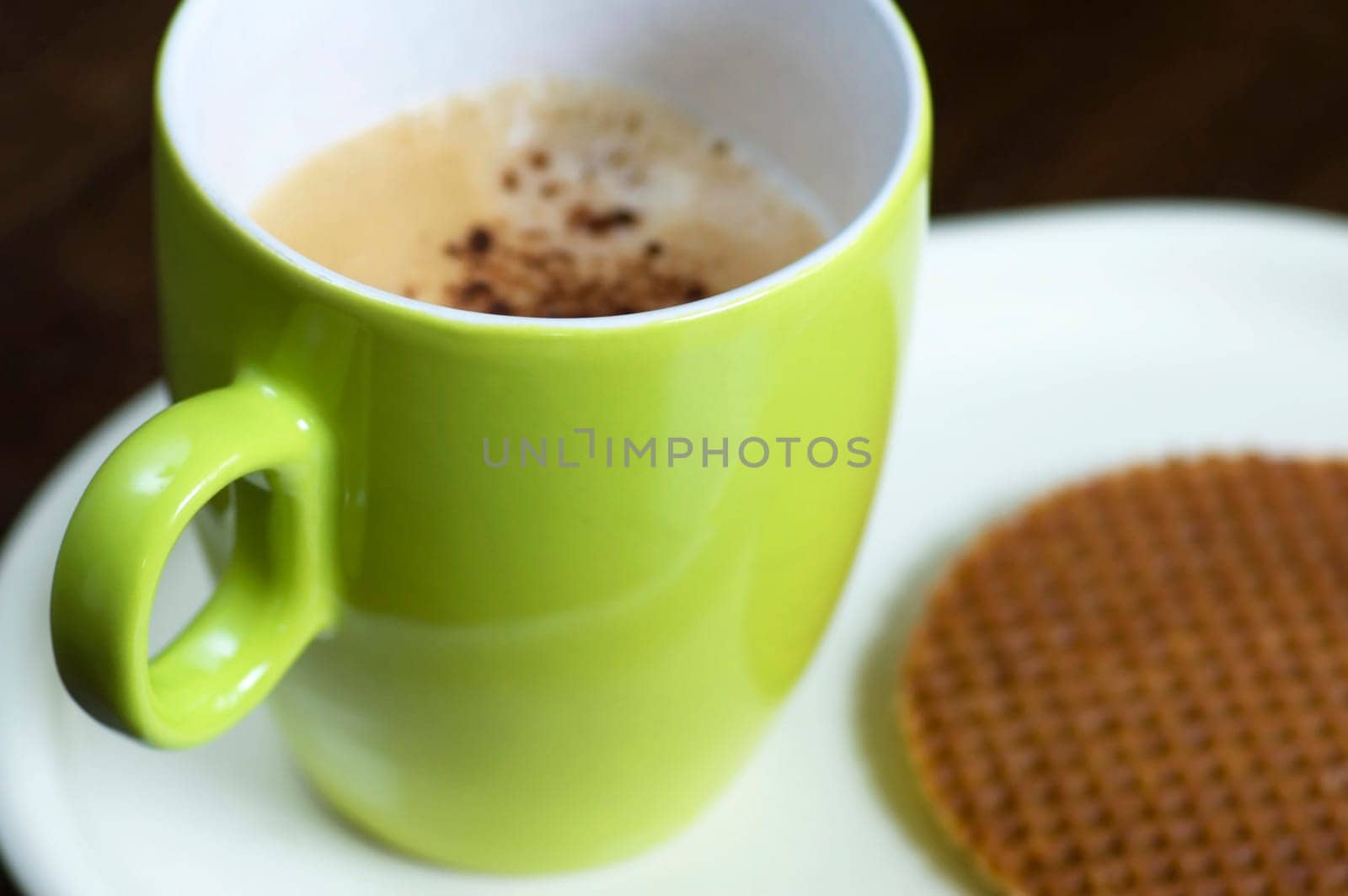 A delicious cup of cappuchino with a cookie.