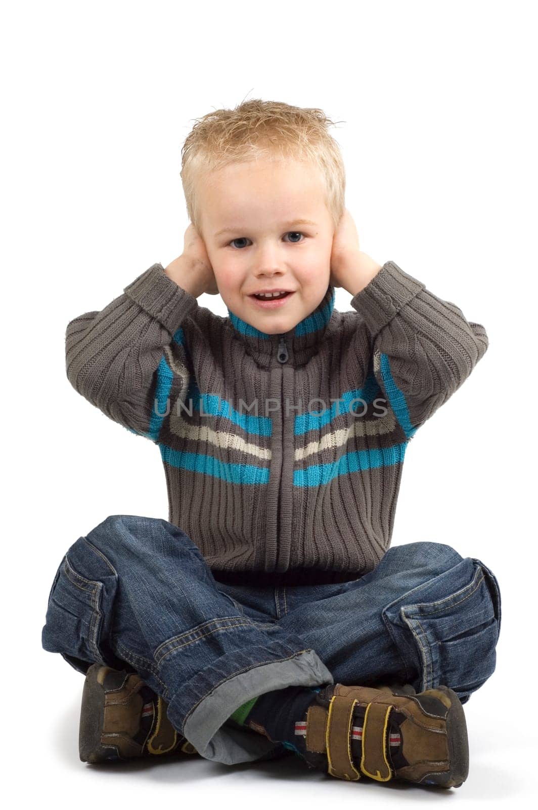 Boy holding his hands against his ears.