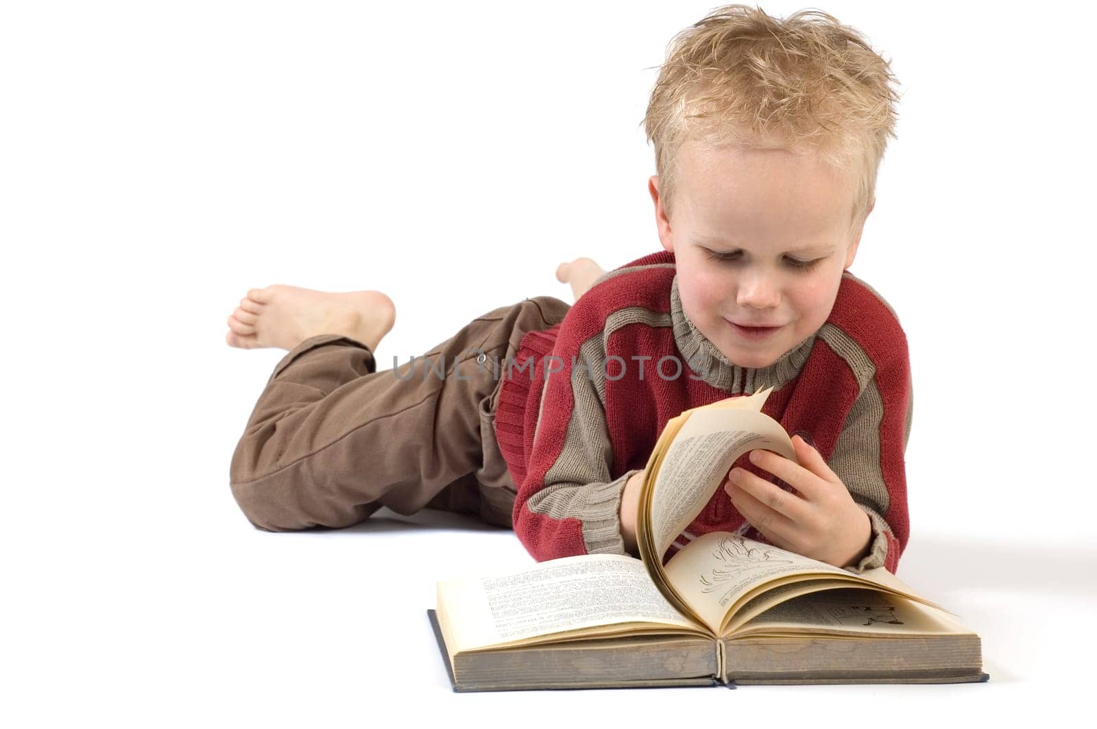 5 year old reading a book, isolated on white. Book is an old children's Bible.