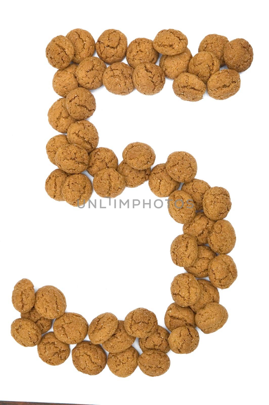 Little ginger nuts in the form of the digit five. These little ginger nuts are used in Holland for the "Sinterklaas"" party, which is at Dec 5 every year. Sinterklaas is a sort of Santa Claus. In Holland these ginger nuts are called ""pepernoot"". Isolated on white."