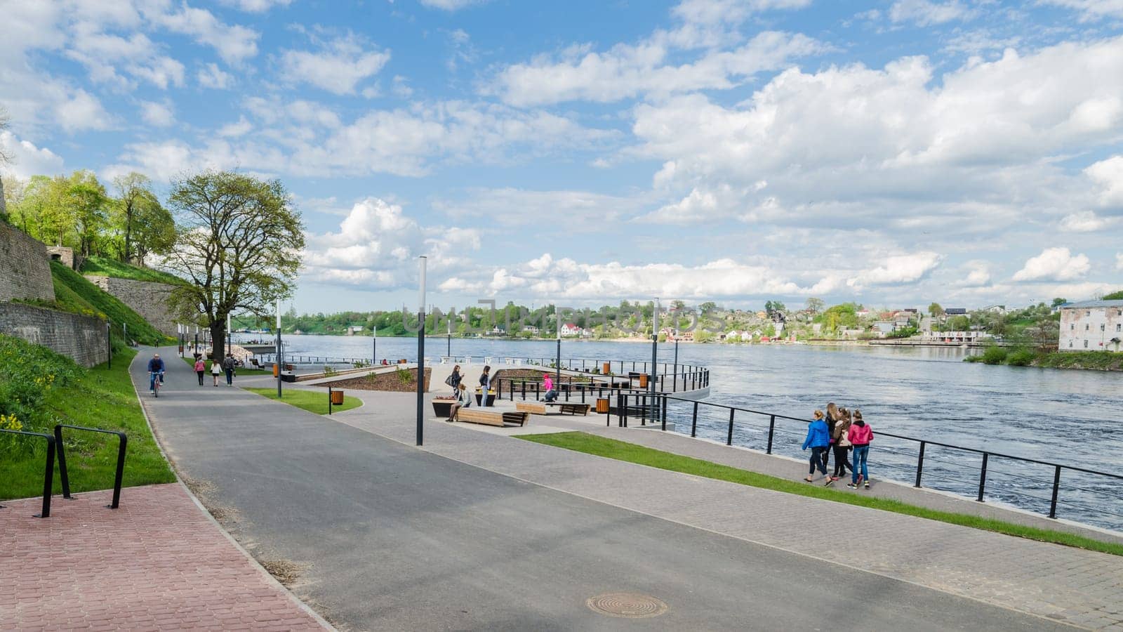 NARVA, ESTONIA - MAY 22 2015: Narva River embankment with vacationers people and the border of Russia and the European Union