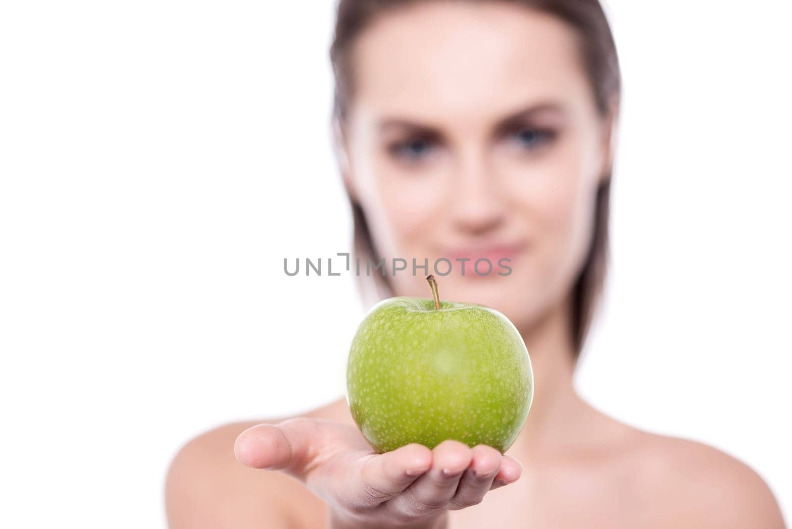 Close up of young woman posing to camera with an apple in her hand