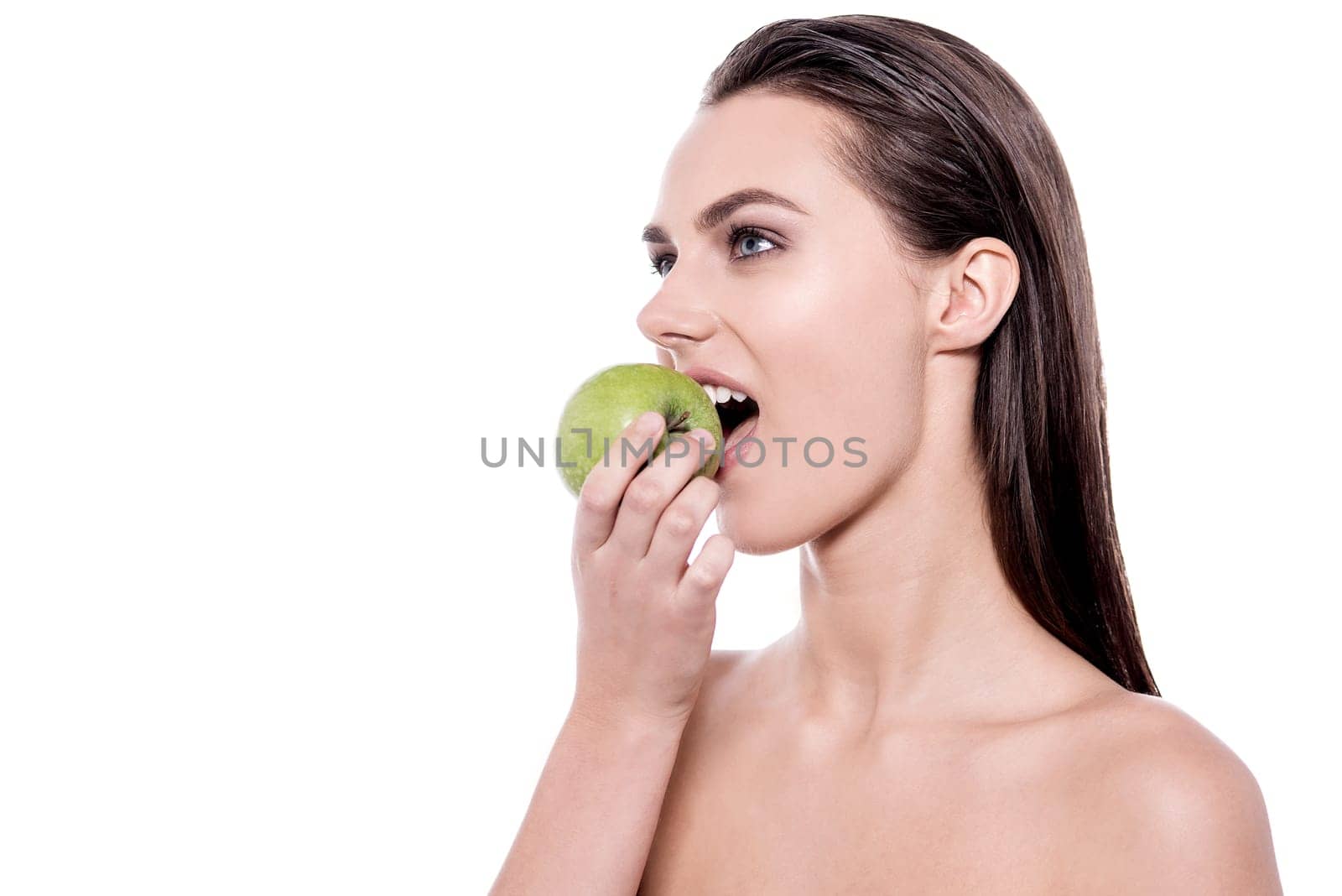 Sideways image of a young woman eating apple
