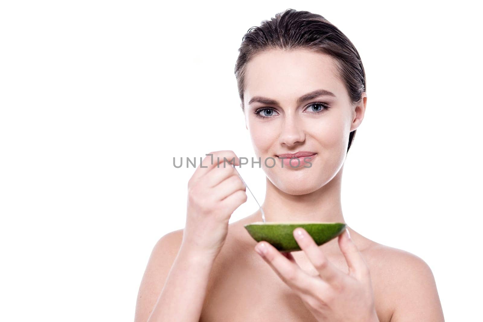 Beautiful spa lady posing with halved avocado