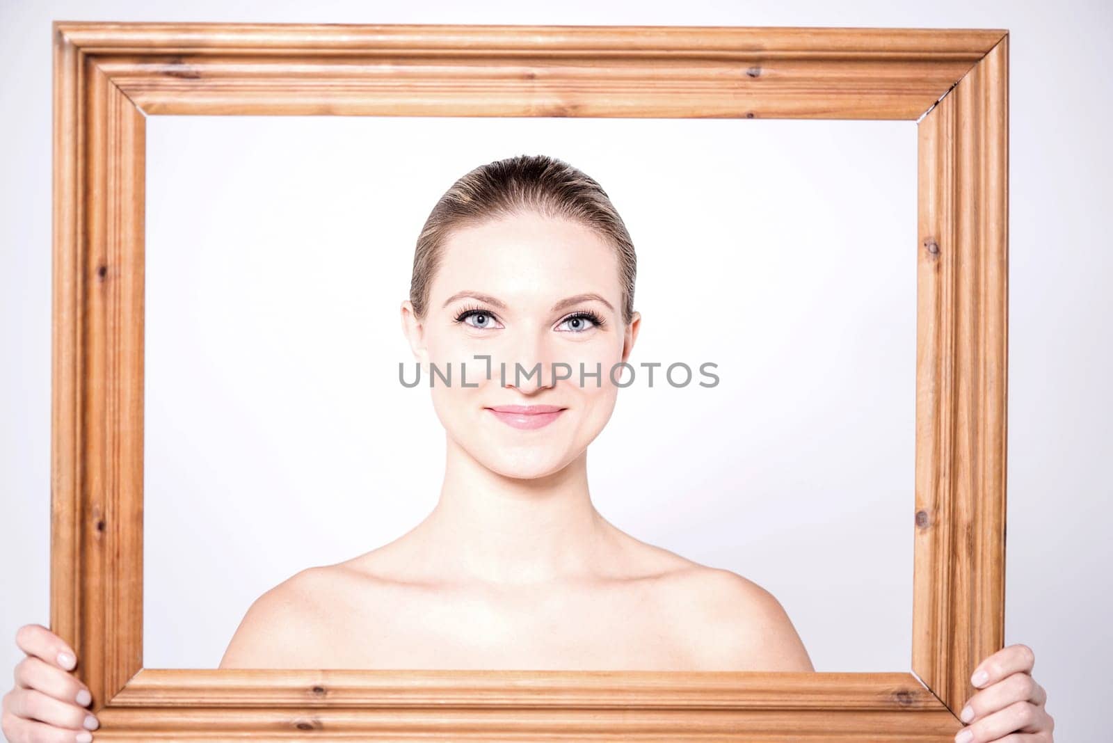Sensual women posing from behind wooden frame