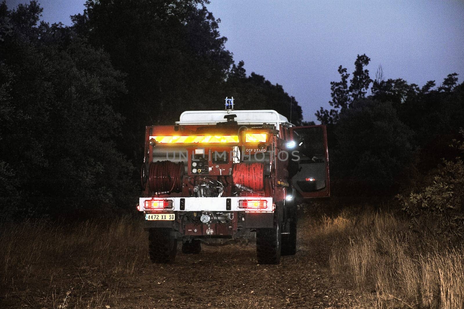 Fire trucks in a forest road the night after a forest fire in the French department of Gard.