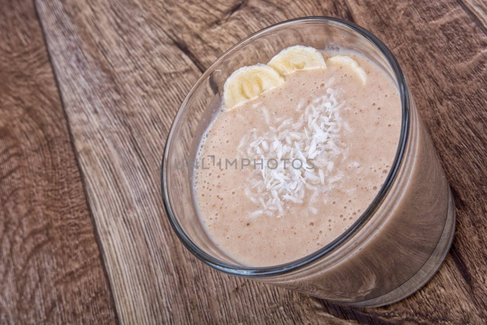 Chocolate drink with coconut and banana on a wooden background