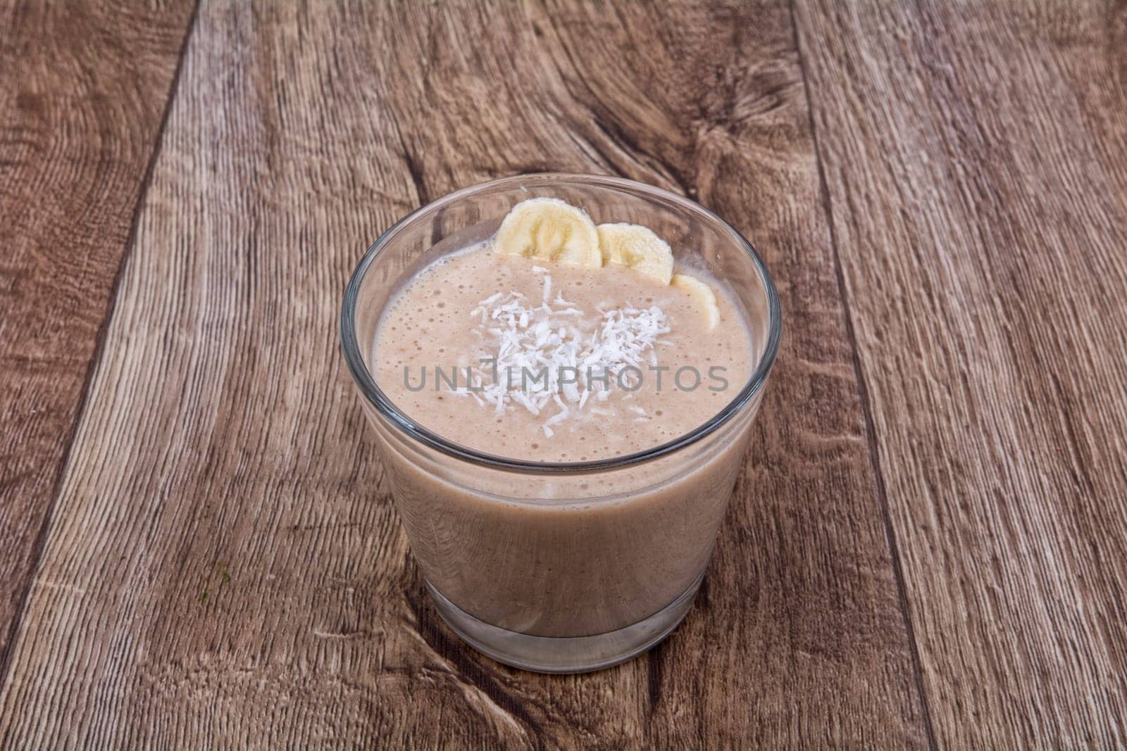 Chocolate drink with coconut and banana on a wooden background