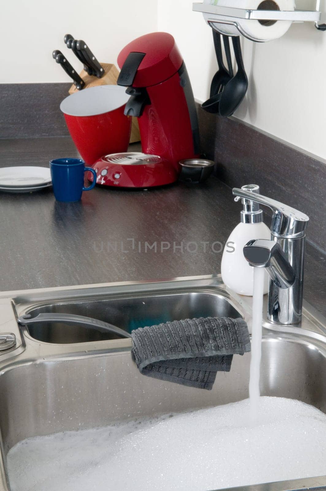 Closeup of a sink in a modern kitchen, ready to do the dishes.
