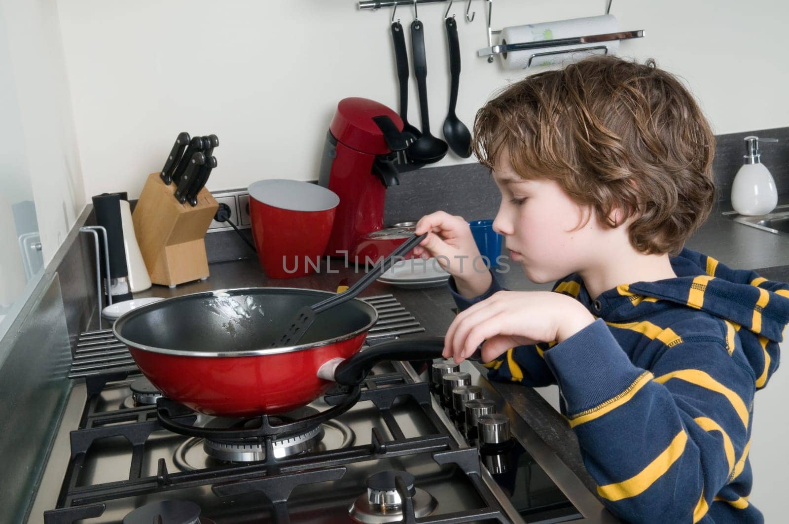Young boy learning to cook in a modern kitchen
