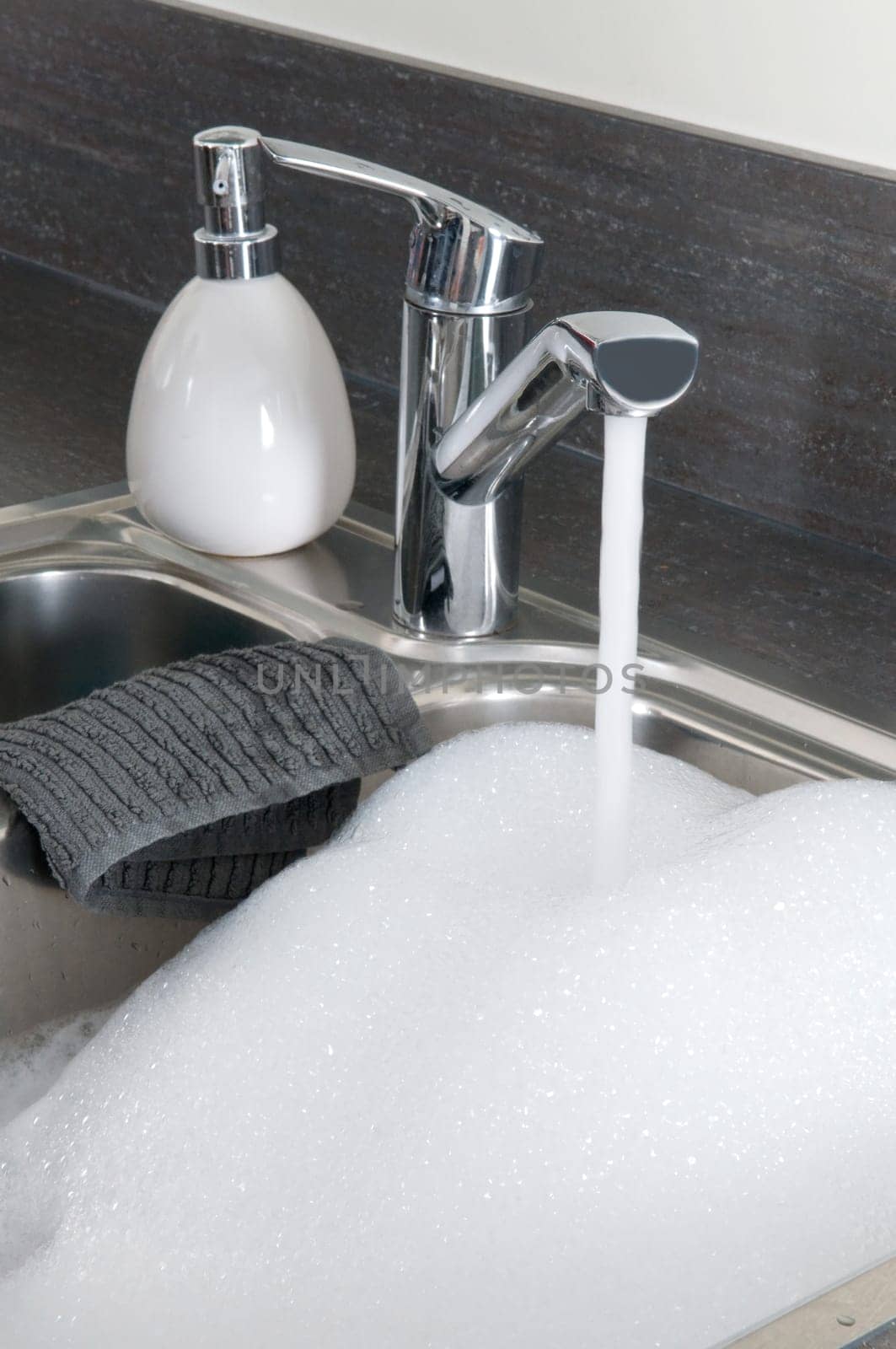 Closeup of a sink in a modern kitchen, ready to do the dishes.