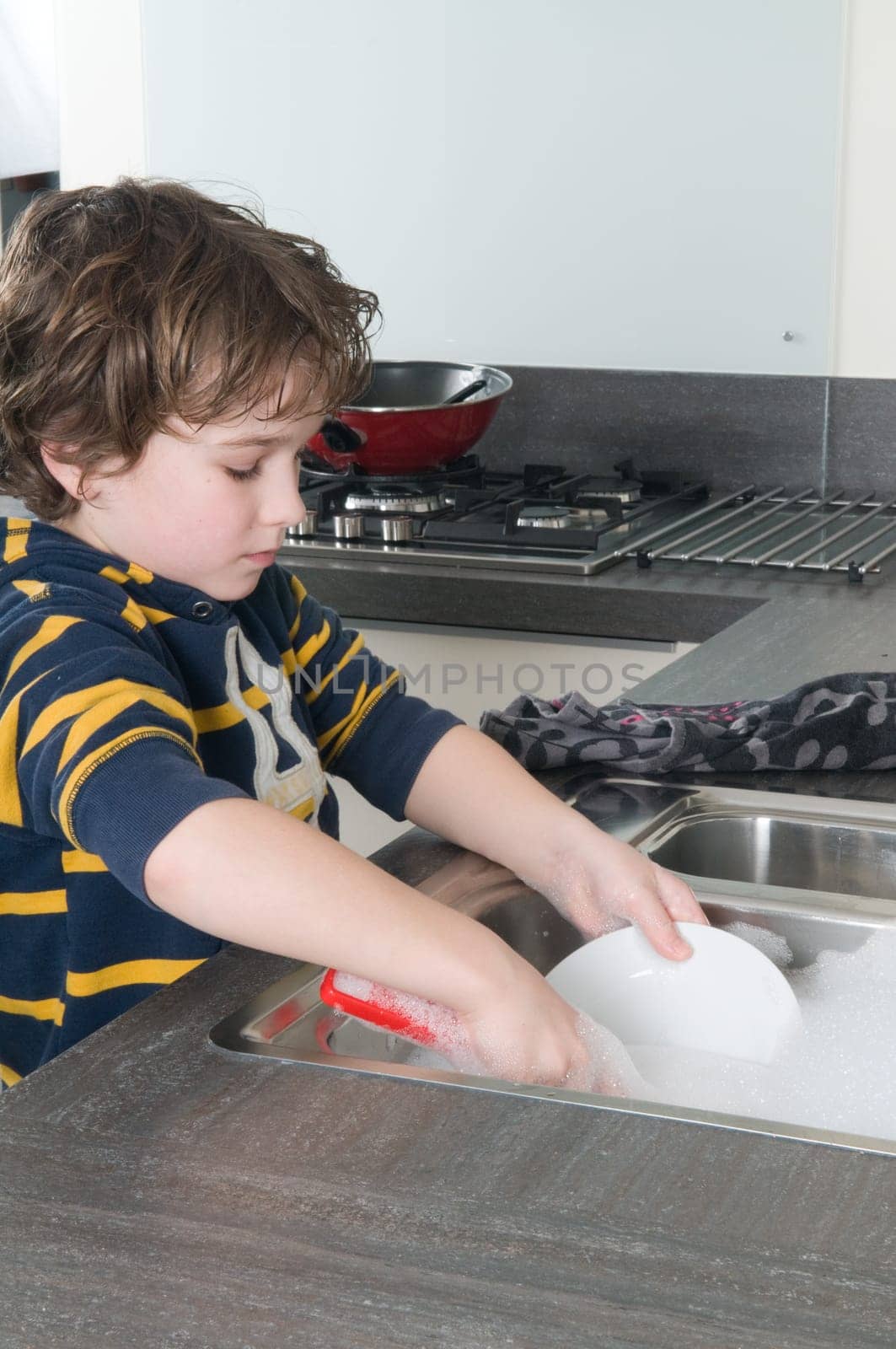 Boy doing the dishes in a modern kitchen