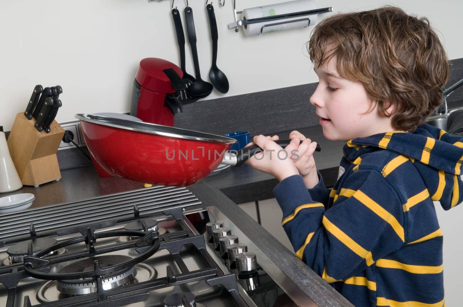 Young boy learning to cook in a modern kitchen