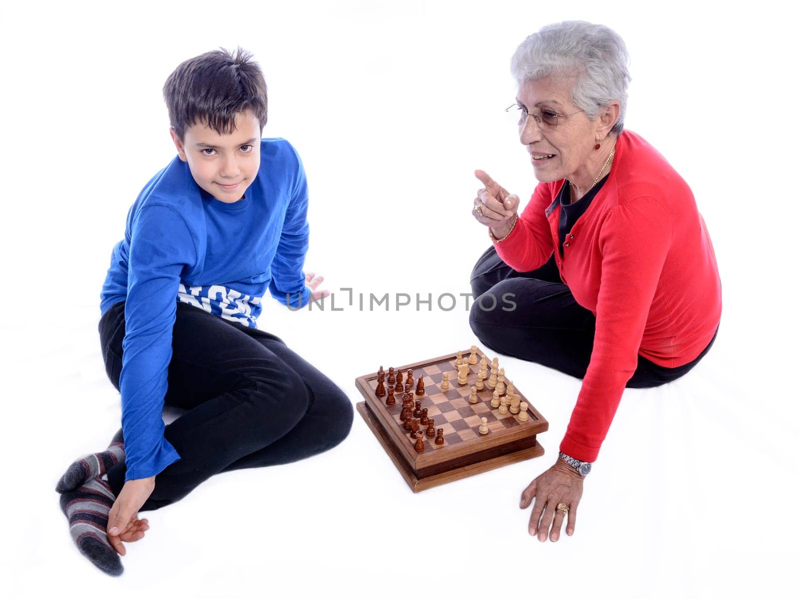 Grandmother with her grandson playing chess. white background.