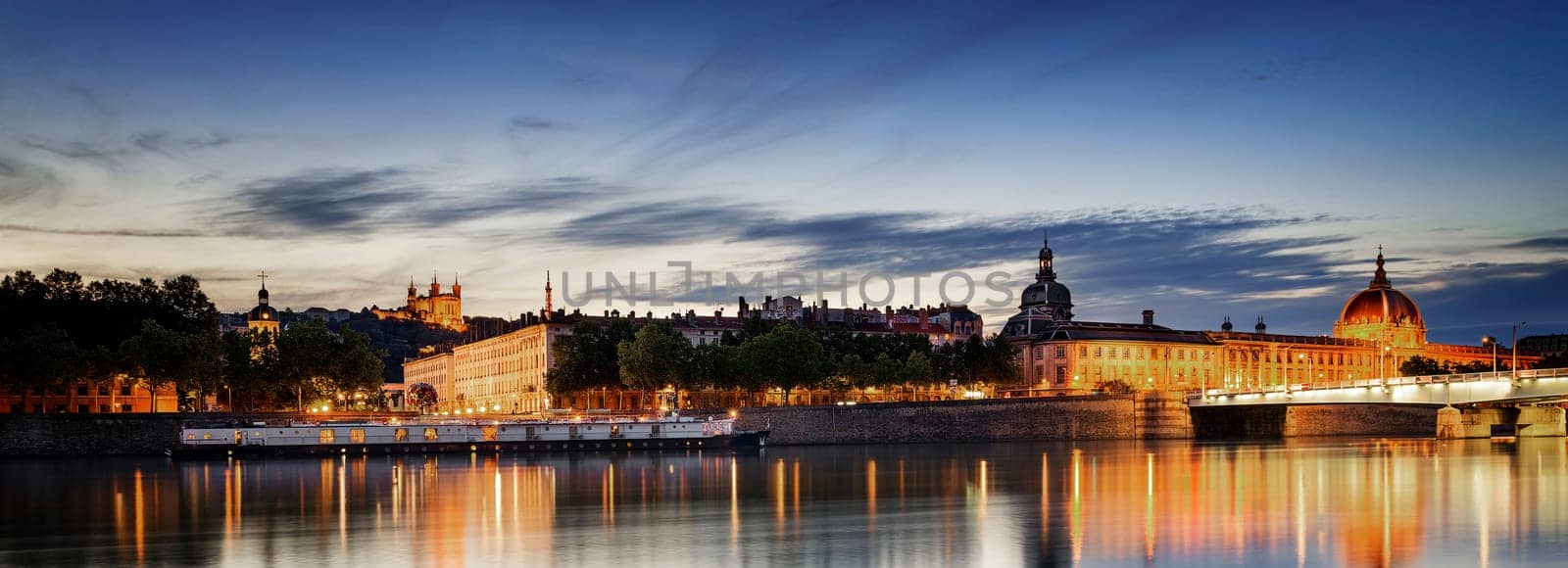 night view from Rhone river in Lyon city with Hotel Dieu and Fourviere cathedral, France
