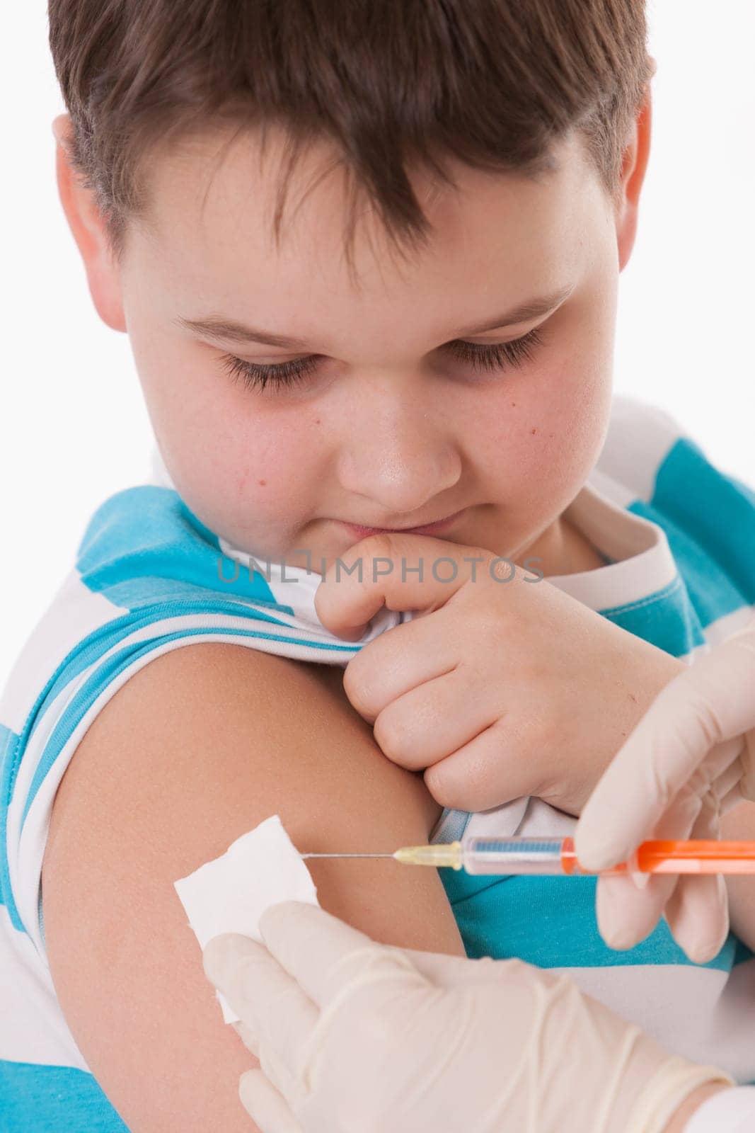 Doctor giving a child injection in arm on isolated image.