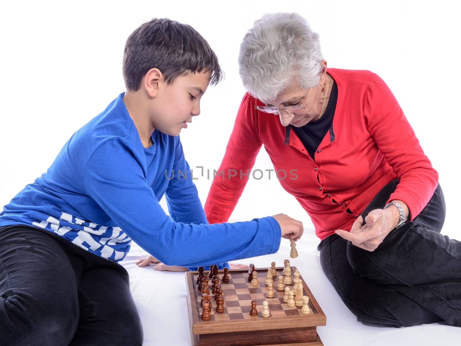Grandmother with her grandson playing chess. white background.
