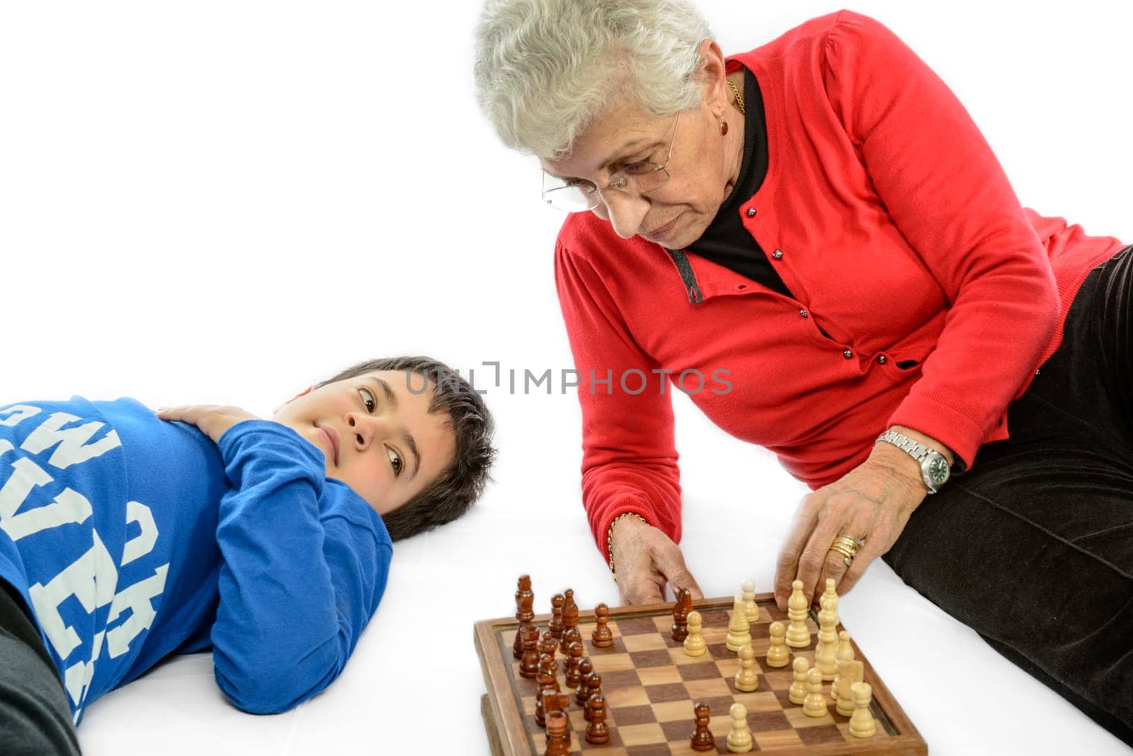 Grandmother with her grandson playing chess. white background.