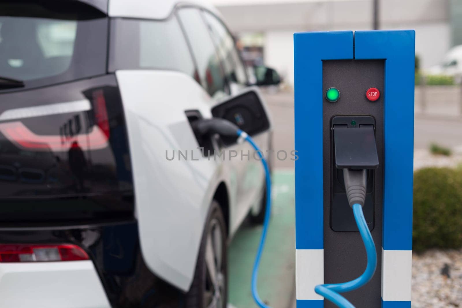 Power supply for electric car charging.  Electric car charging station. Close up of the power supply plugged into an electric car being charged.