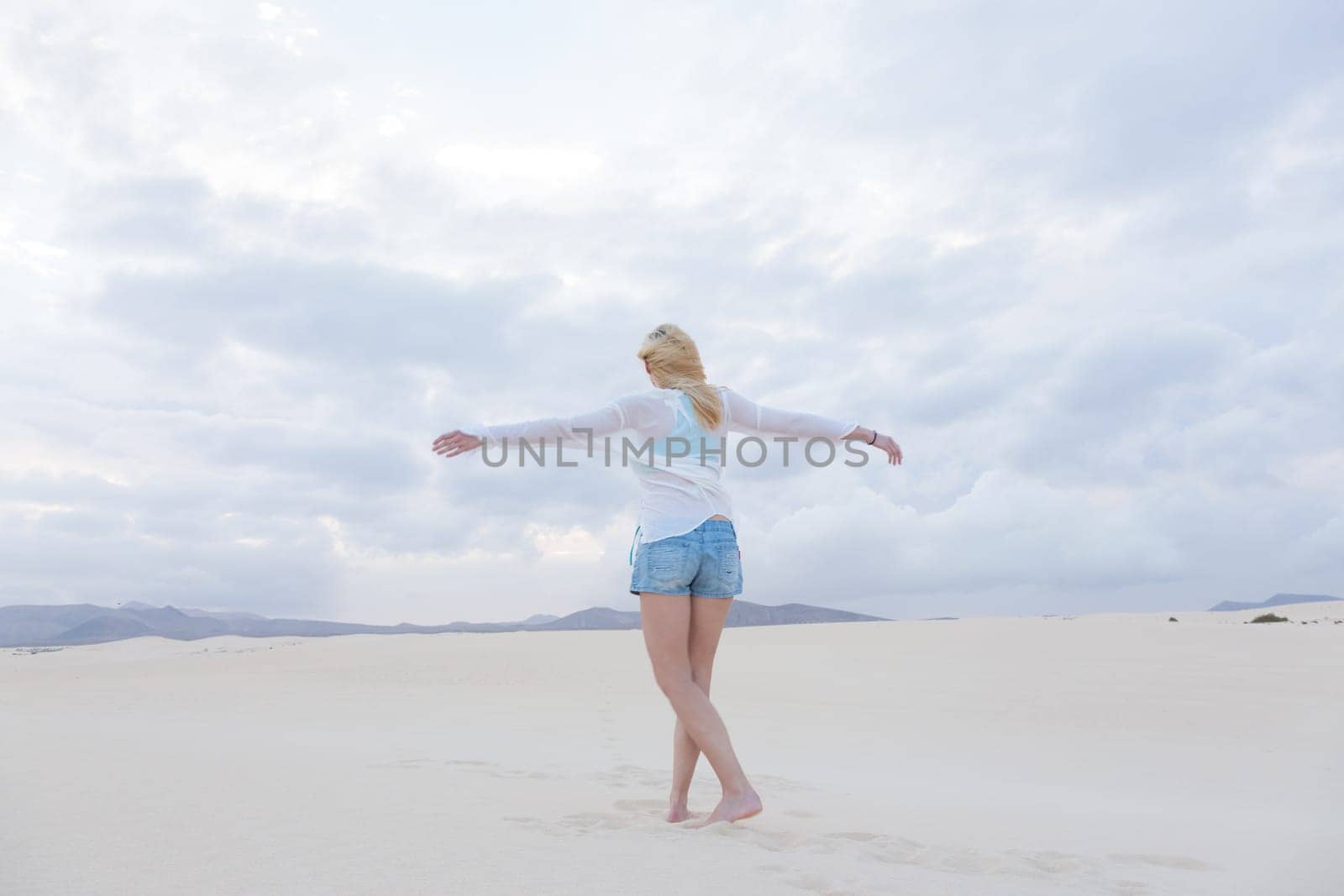 Relaxed woman enjoying freedom feeling happy at beach in the morning. Serene relaxing woman in pure happiness and elated enjoyment with arms outstretched. Copy space.