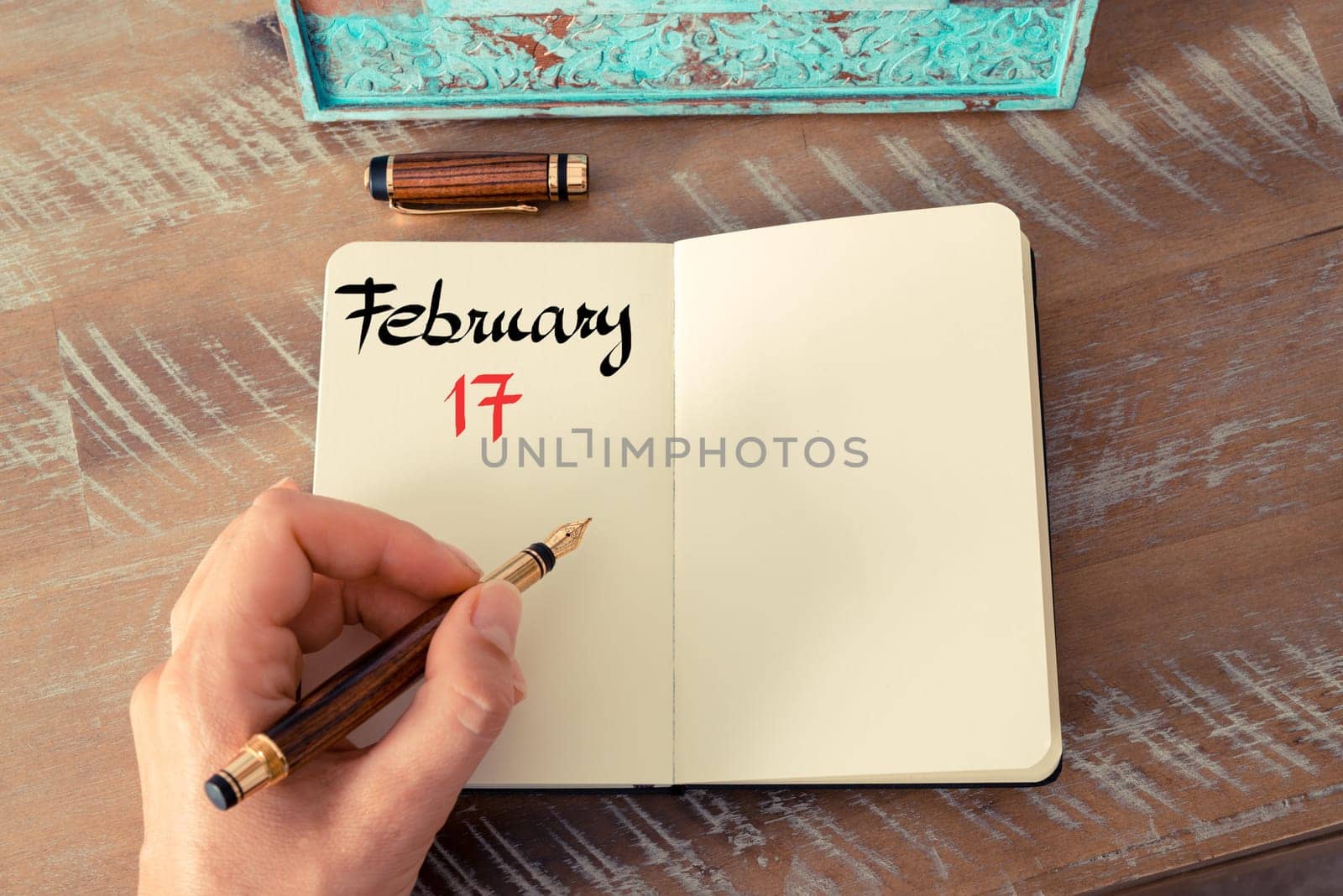 Concept image of February 17 Calendar Day with empty space for text as handwritten note with fountain pen on a notebook