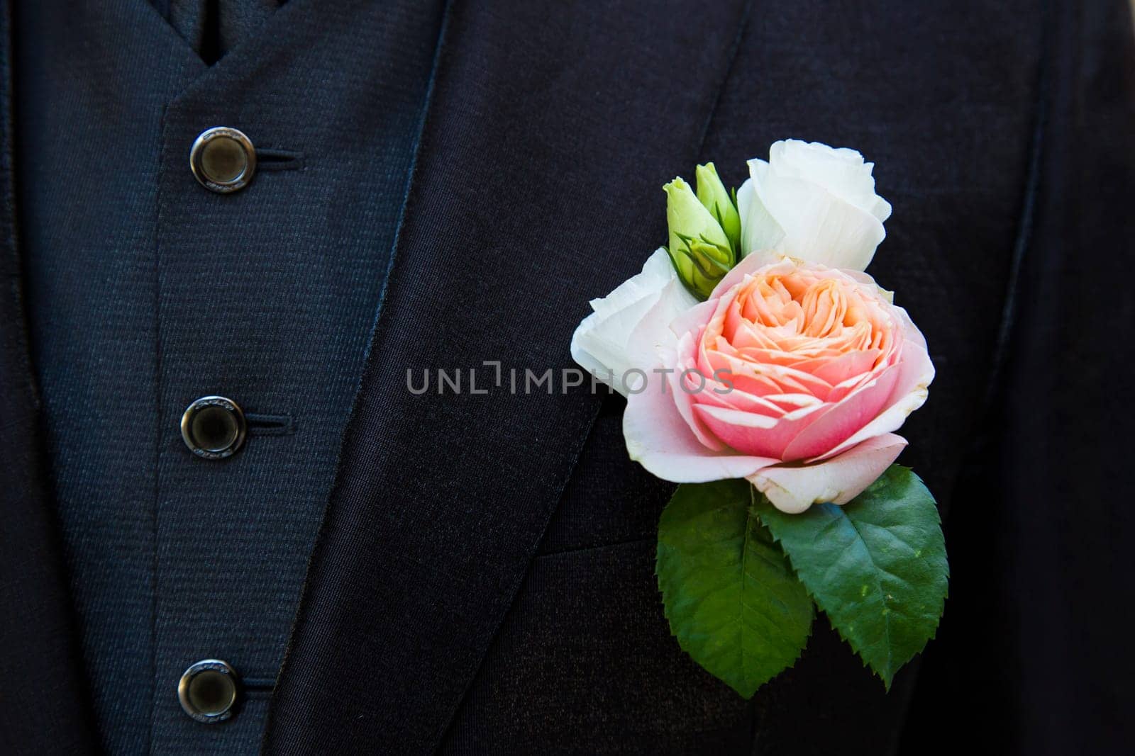Close up view of a particular floral accessory on a groom's suit