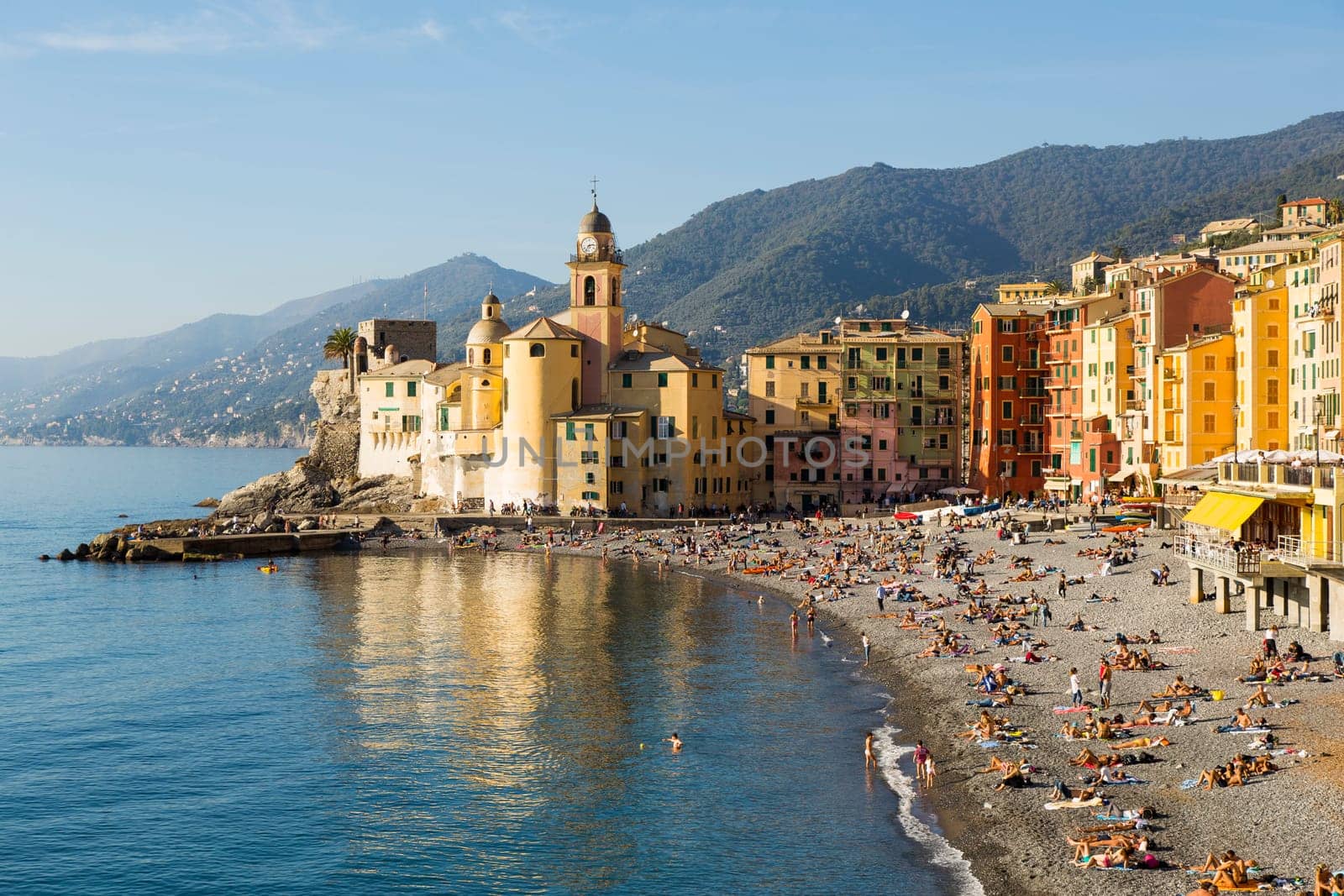 Panoramic view of a seaside town in the foreground beach an church in the background on a sunny day