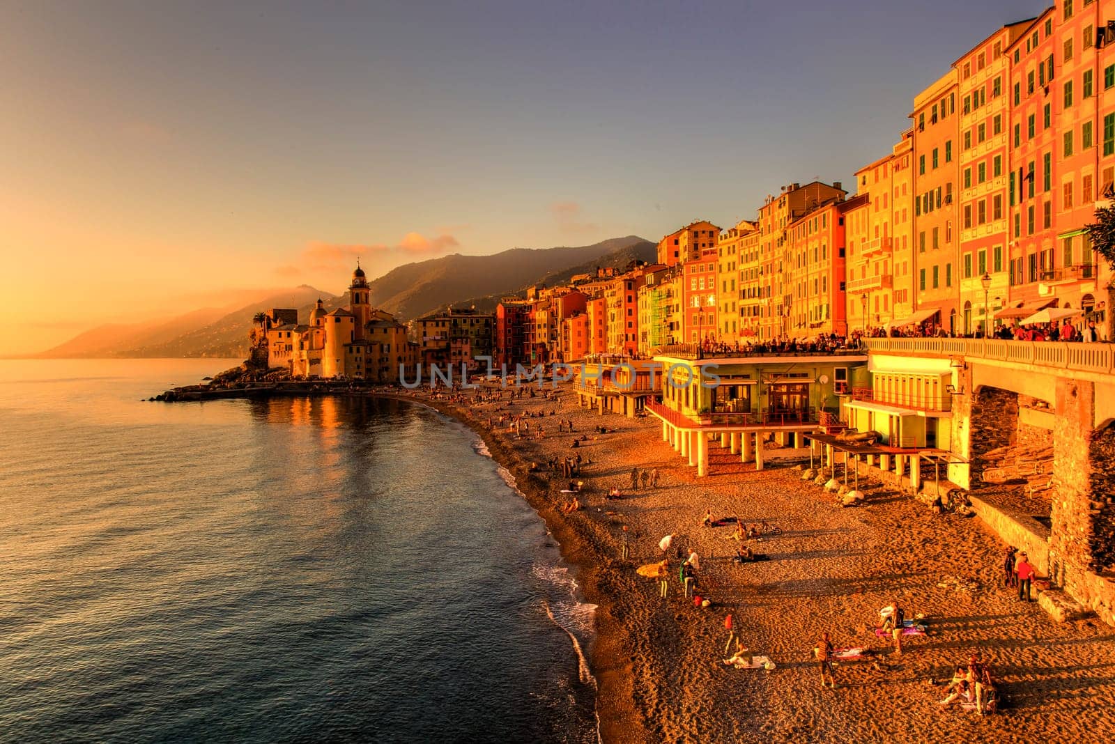 Panoramic view of a seaside town in the foreground beach an church in the background at sunset