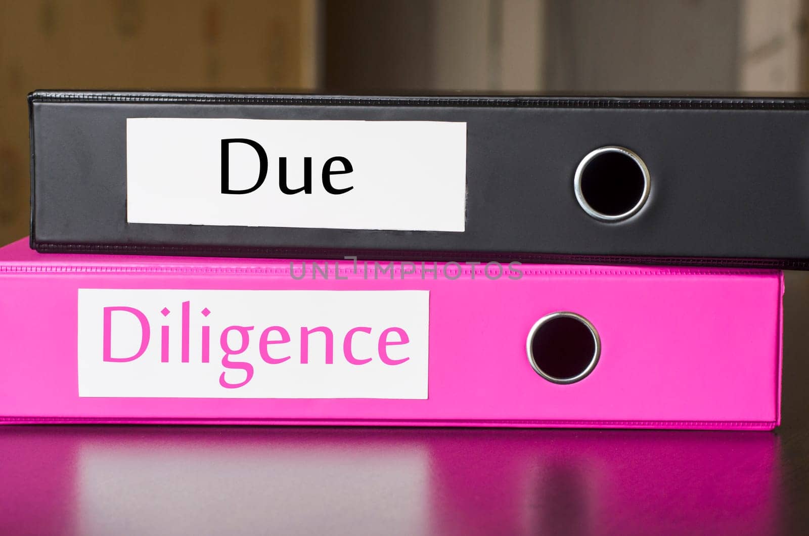 Bright office folders over dark background and due diligence text concept