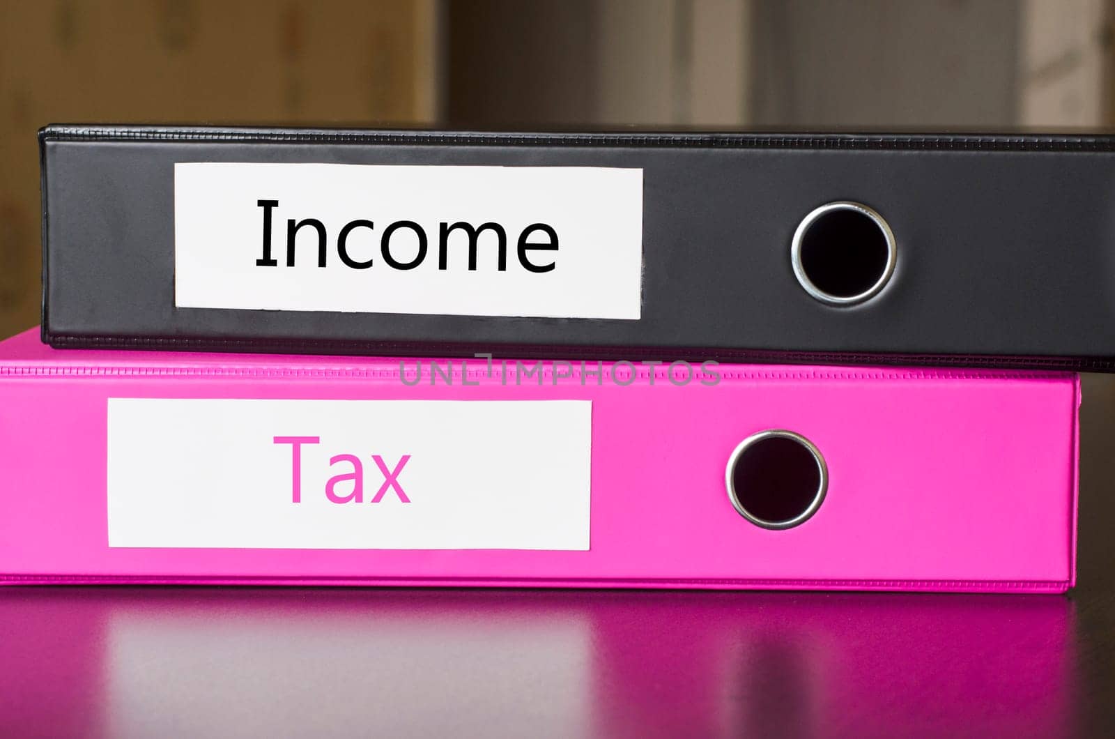 Bright office folders over dark background and income and tax text concept