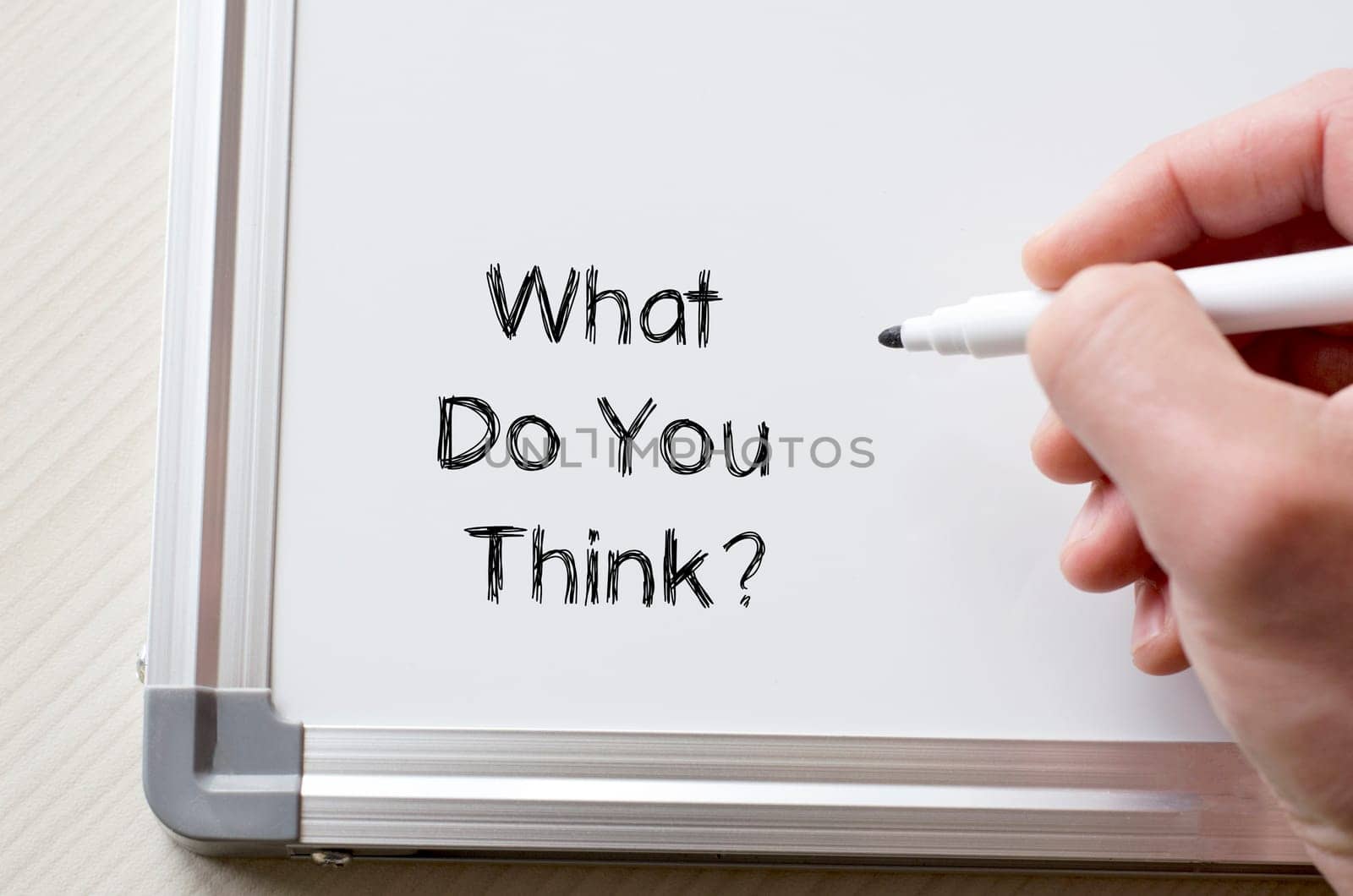 Human hand writing what do you think on whiteboard