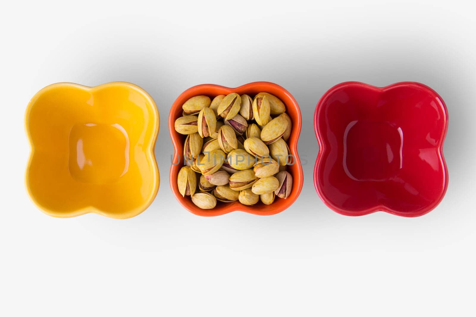 Pistachio Nuts on Colorful Bowls Isolated on White Background, Cllipping Path Included.