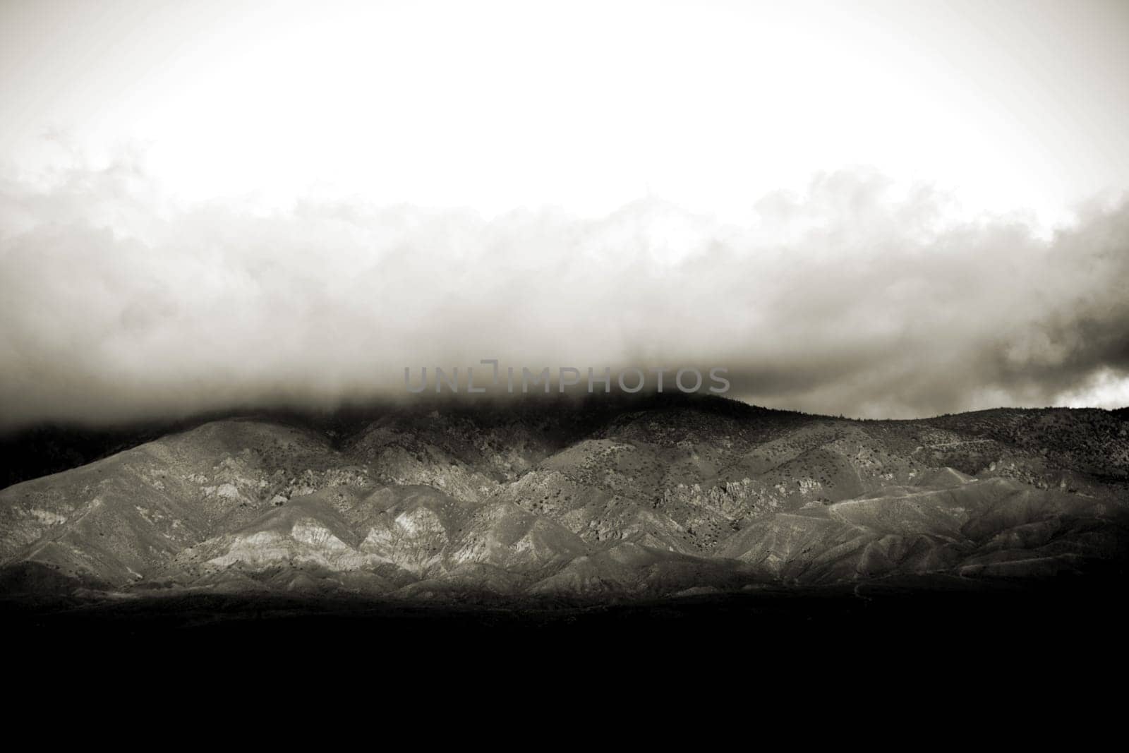 Clouds and fog move over the peaks and ridges of a mountain range.