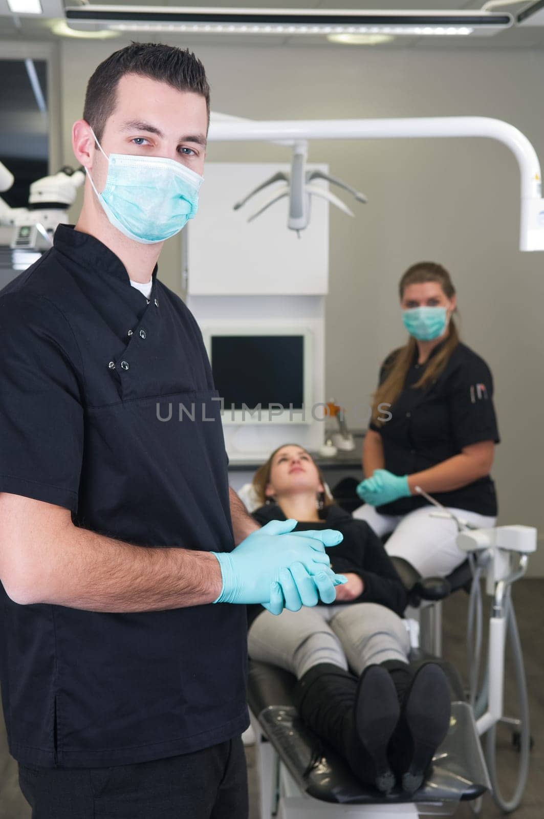 Dentist in the front, nurse and patient in the background