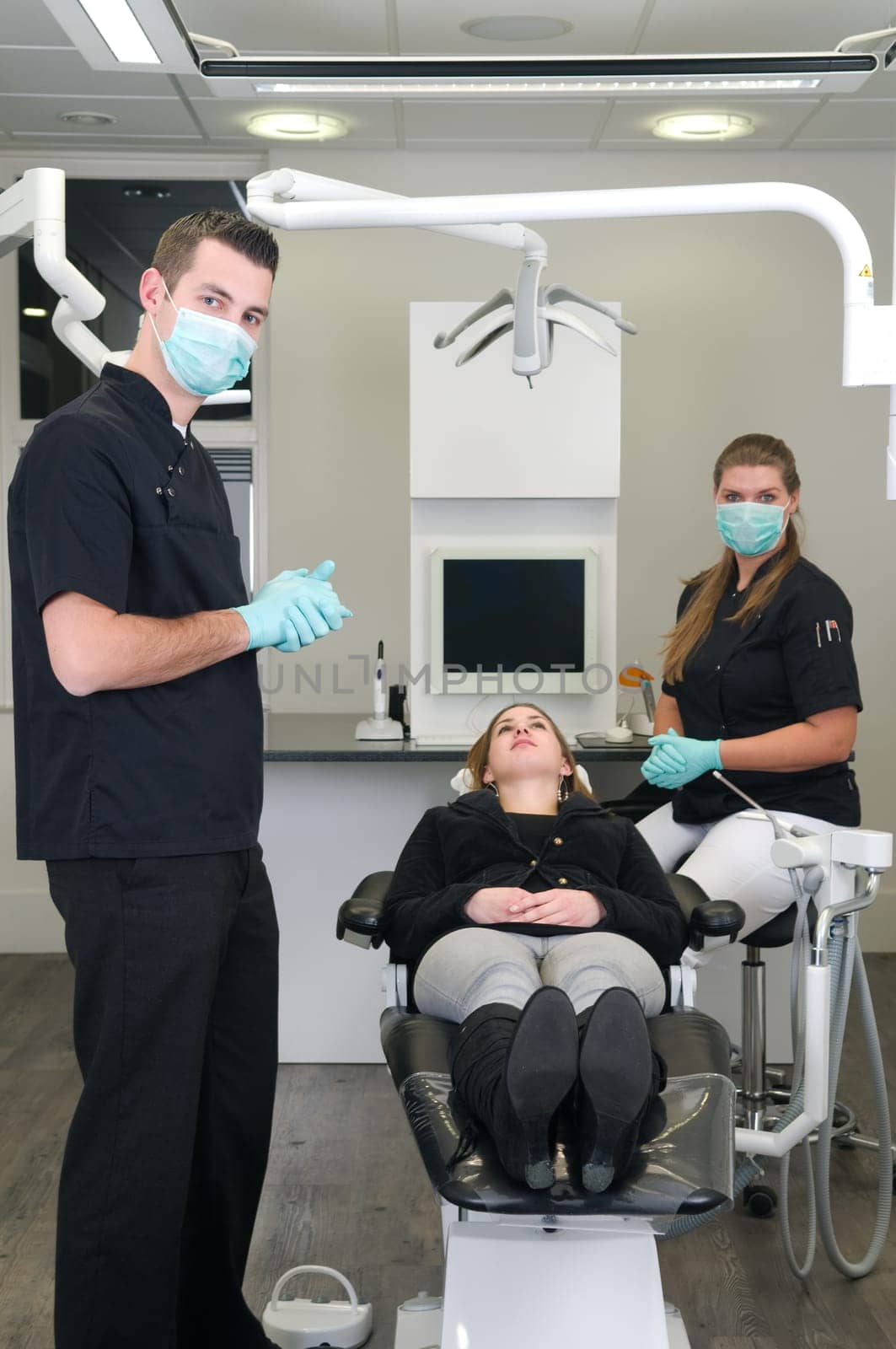 Dentist in the front, nurse and patient in the background