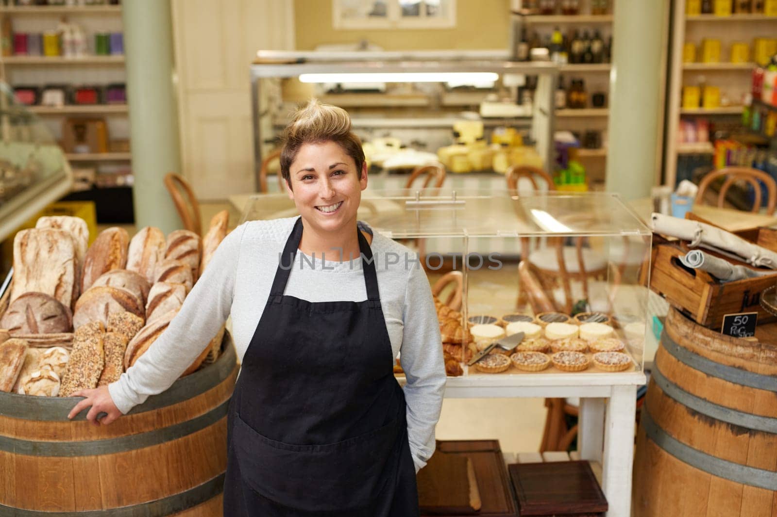 A young deli employee standing in front of the pastry display