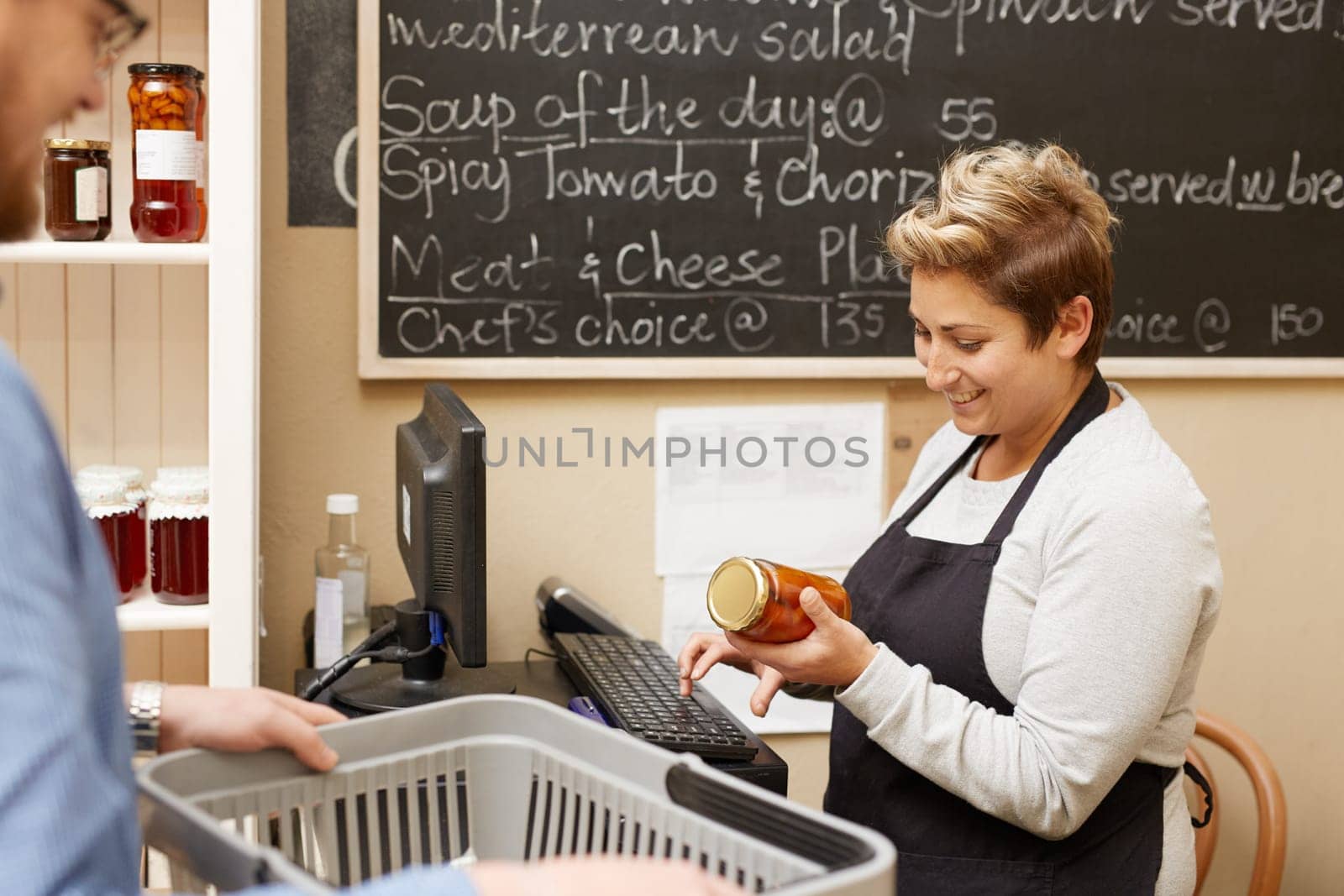 A female deli employee ringing up a young man&#39 s purchases