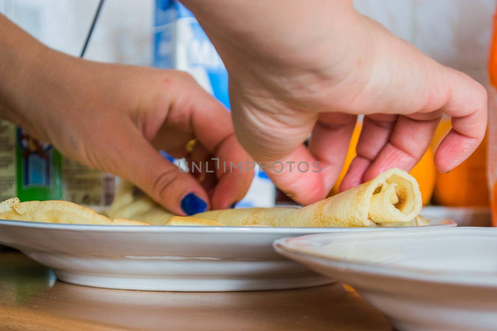 Aranging pancakes on a plate in the kitchen