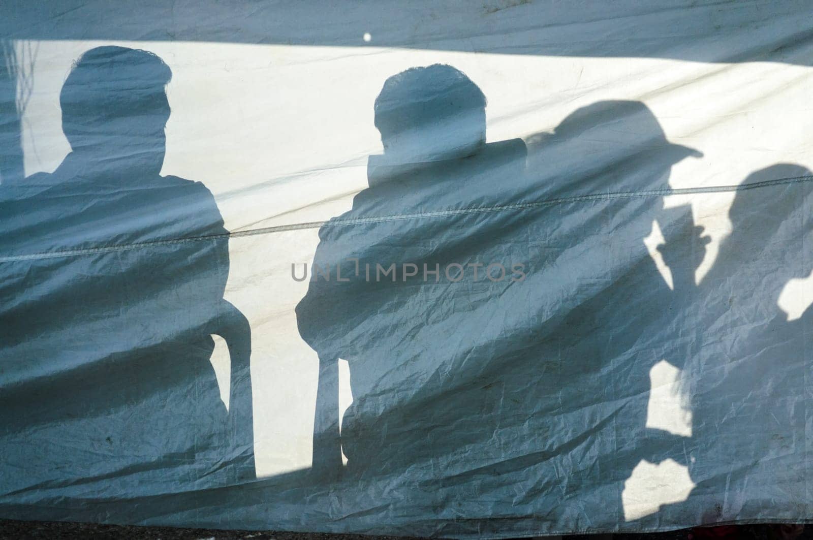 Silhouettes of four people on a tarp in Mexico City