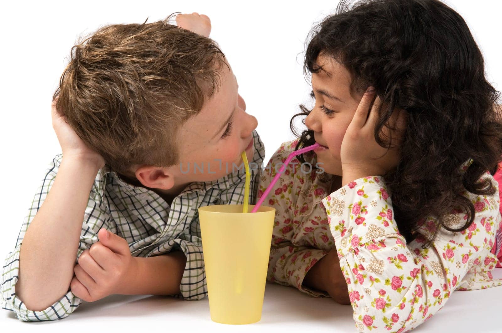 Boy and a girl drinking together with a straw.