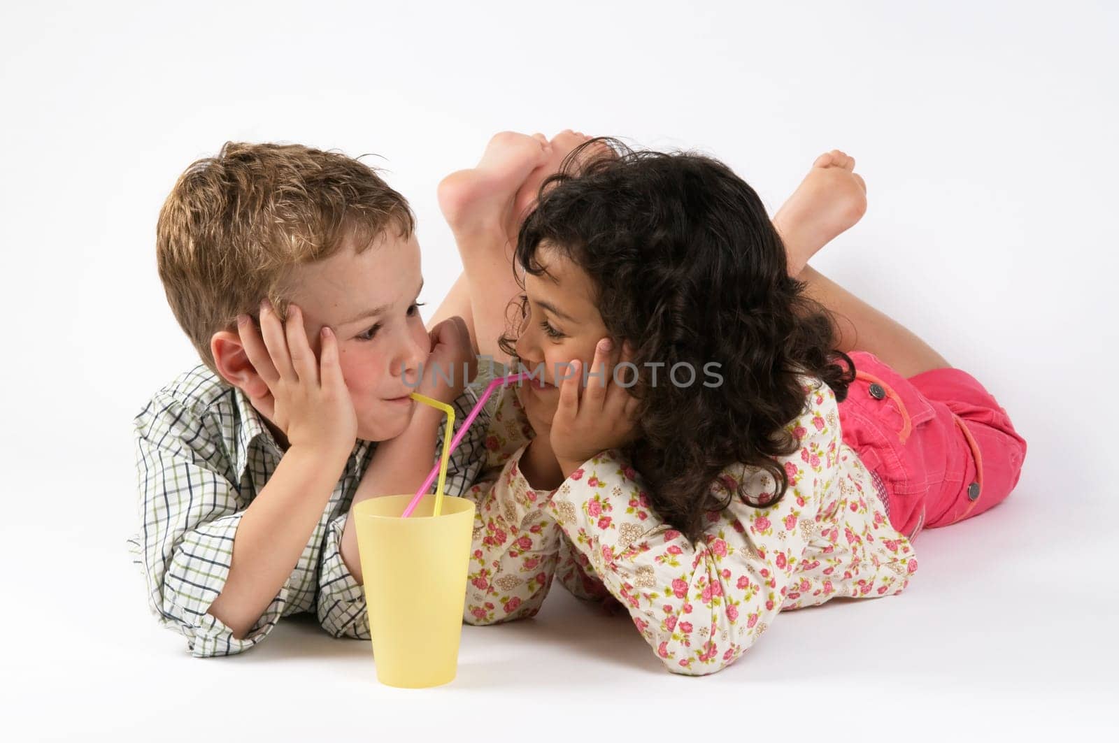 Two friends drinking together, looking at each other.